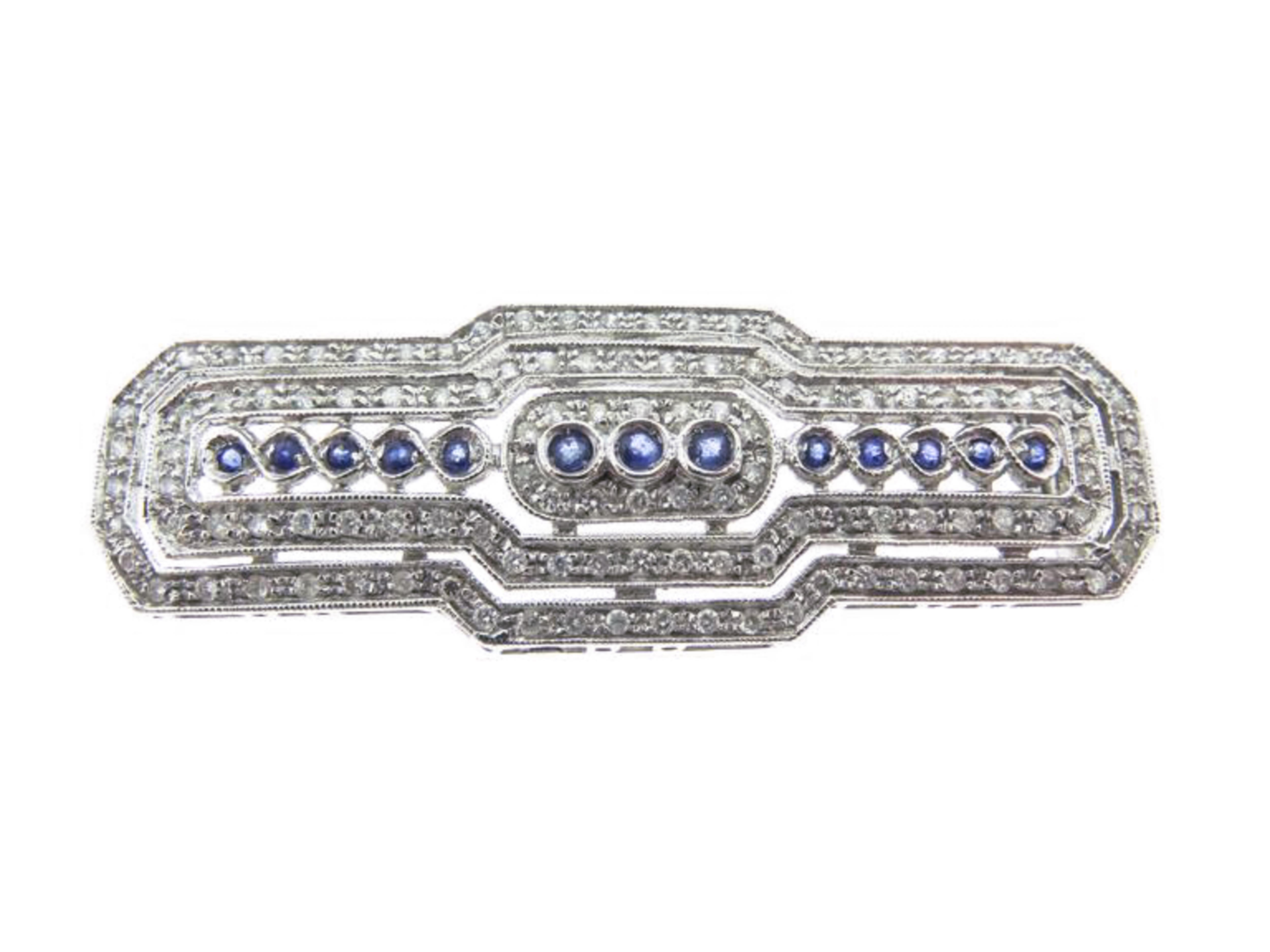 The white gold brooch is beautifully decorated with diamonds, the amount in carat is over 1.40 carat, at the center is a line of 13 natural sapphires weighing 0.50 carat. The design is classic Art Deco style. Gorgeous architecture and platinum