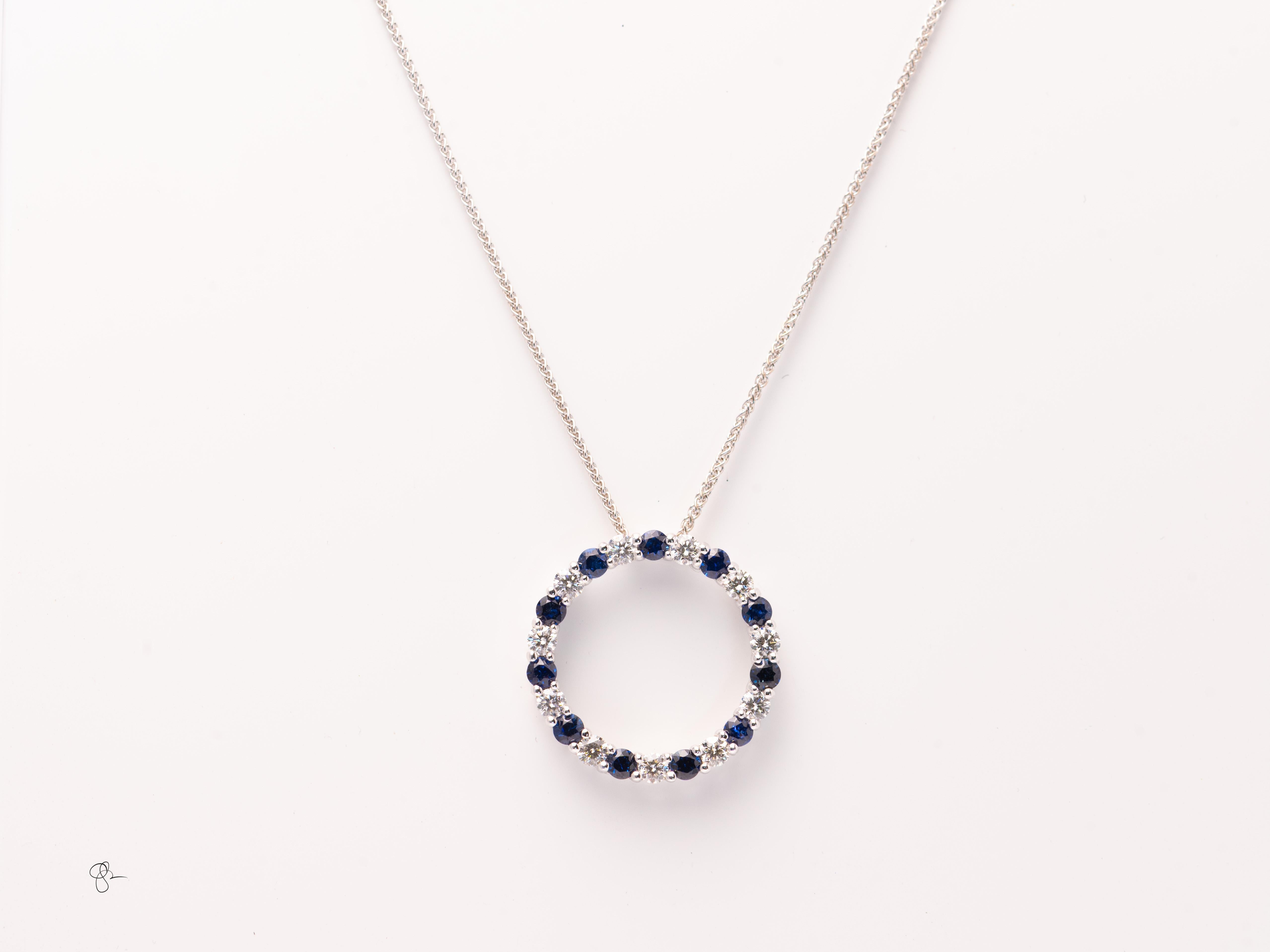 Realizzato in 4,9 grammi di oro bianco 14 e appeso a una sottile catena di grano in oro bianco.
Il ciondolo a forma di cerchio è incastonato con un'alternanza di  2.6mm  diamanti rotondi e zaffiri rotondi, si stima che ci siano circa 0,70 carati di 