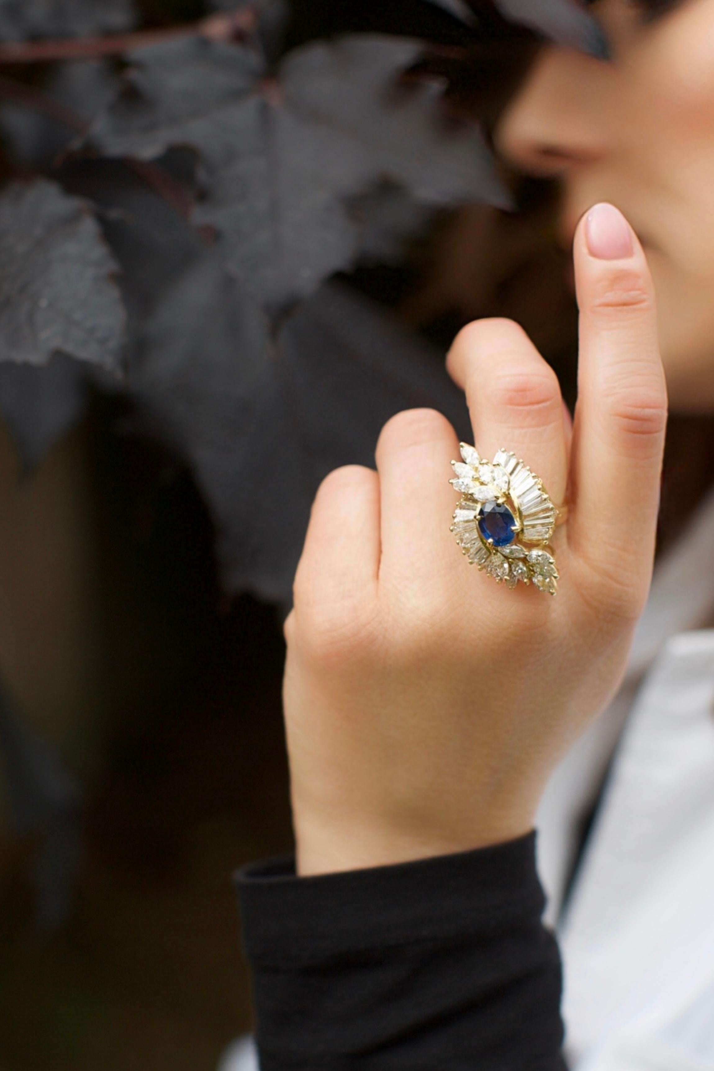 Bague de cocktail en saphir et diamant montée en or jaune 18kt. Le modèle présente un saphir central ovale facetté, entouré de 34 diamants taille marquise et baguette disposés en éventail stylisé rayonnant.

Dimensions : Environ 28 mm x 22 mm x 14
