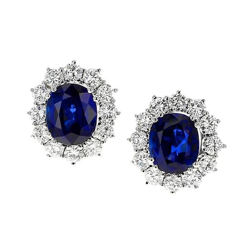 An impressive pair of earrings set with oval mixed-cut vivid blue sapphires, weighing approximately a total of 12.69 ct., with set of a cluster of round, brilliant-cut diamonds weighing approximately 4.80 ct. set in Platinum and White Gold,