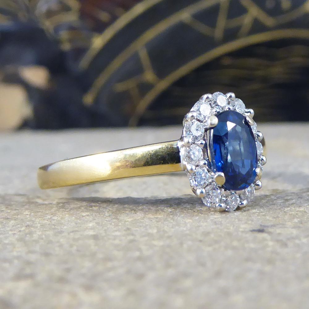 This lovely blue Sapphire weighs 0.65ct with a surround of Diamonds weighing 0.12ct in total of modern brilliant cut Diamonds. All the gems are set in claw settings crafted from 18ct White Gold leading down to an 18ct Yellow Gold band. 

Sapphire