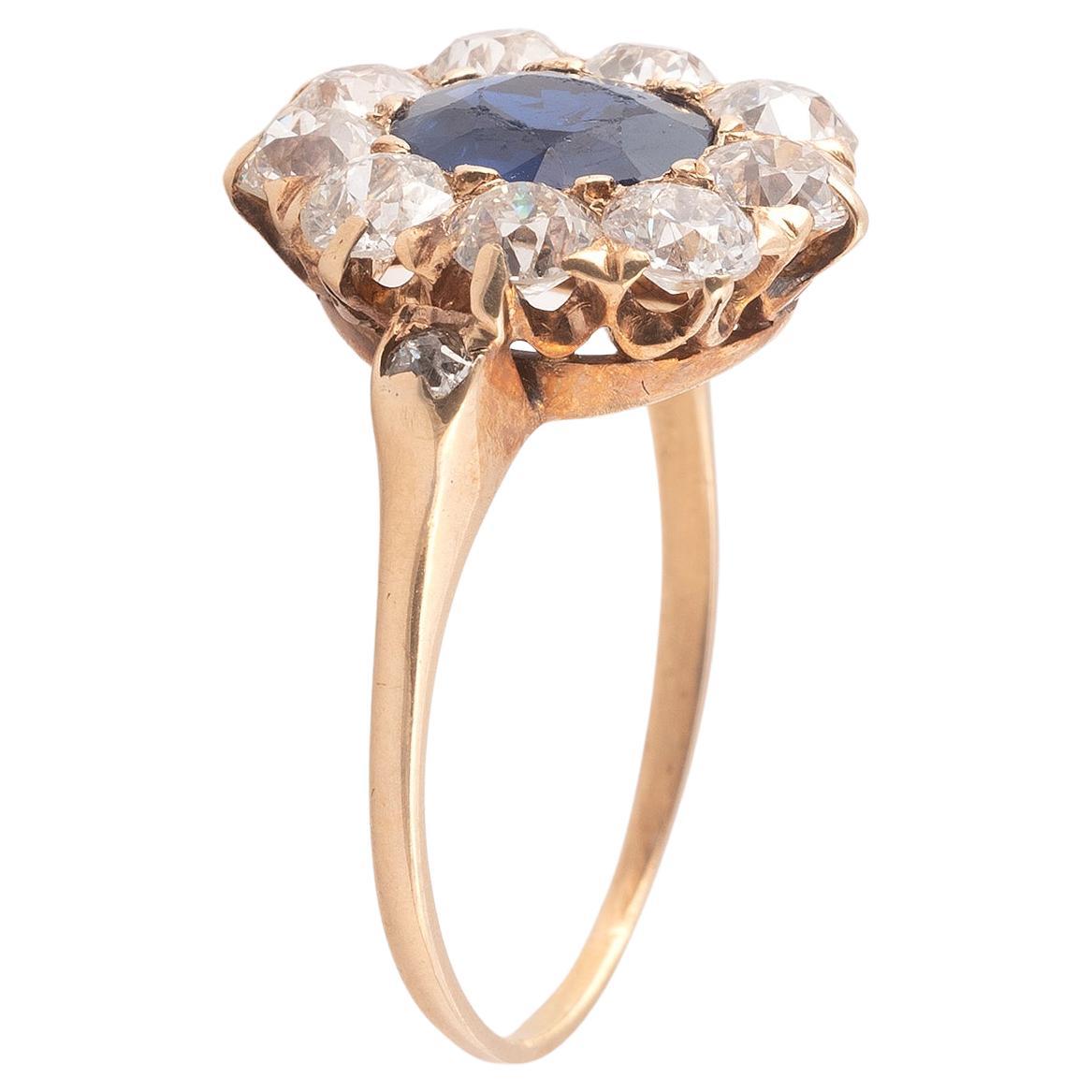 The circular-cut sapphire approx 1.20cts, within a surround of cushion and old brilliant-cut diamonds, diamonds approx 1.26cts total, ring size approx 6 1/2