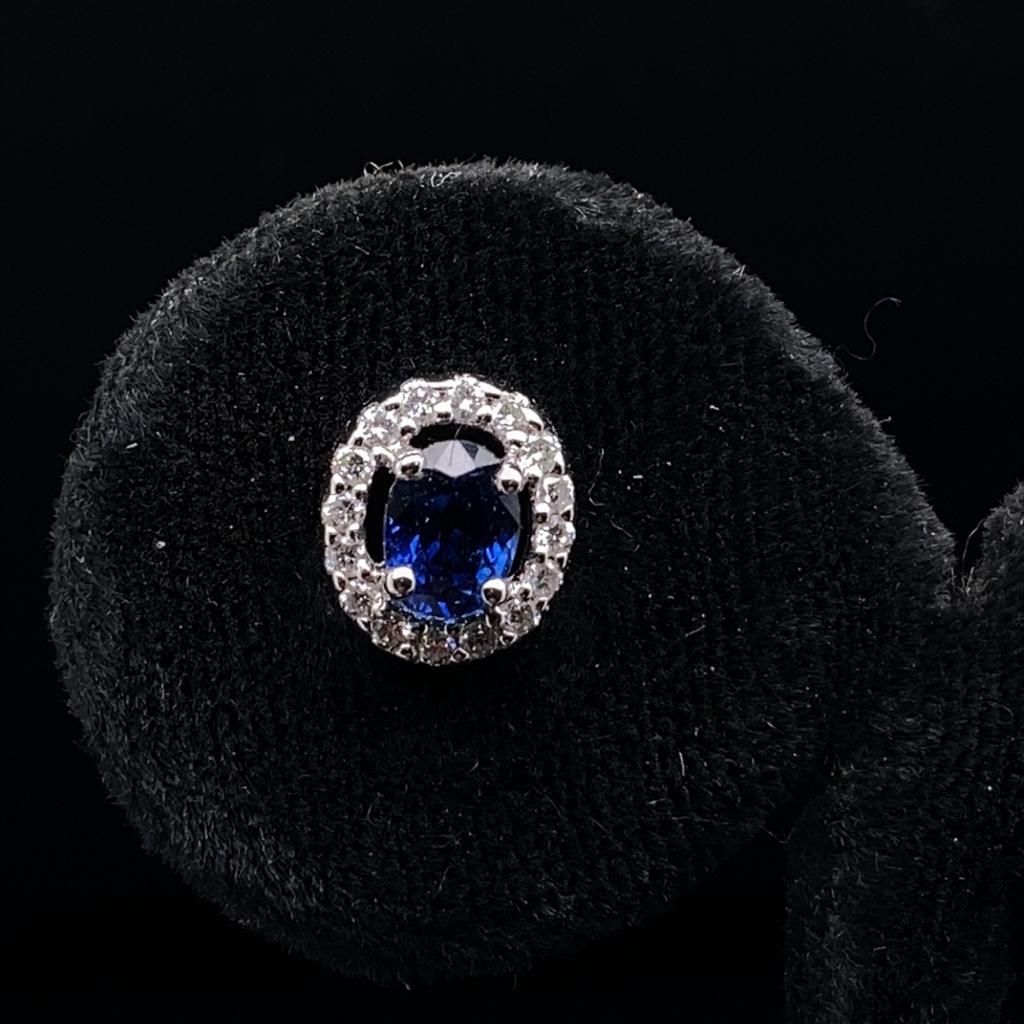 A pair of sapphire and diamond cluster earrings in 18 karat white gold.

Each of these stud earrings comprise of a beautiful oval brilliant cut sapphire of fine quality surrounded by a claw set halo of sparkling round brilliant cut diamonds.