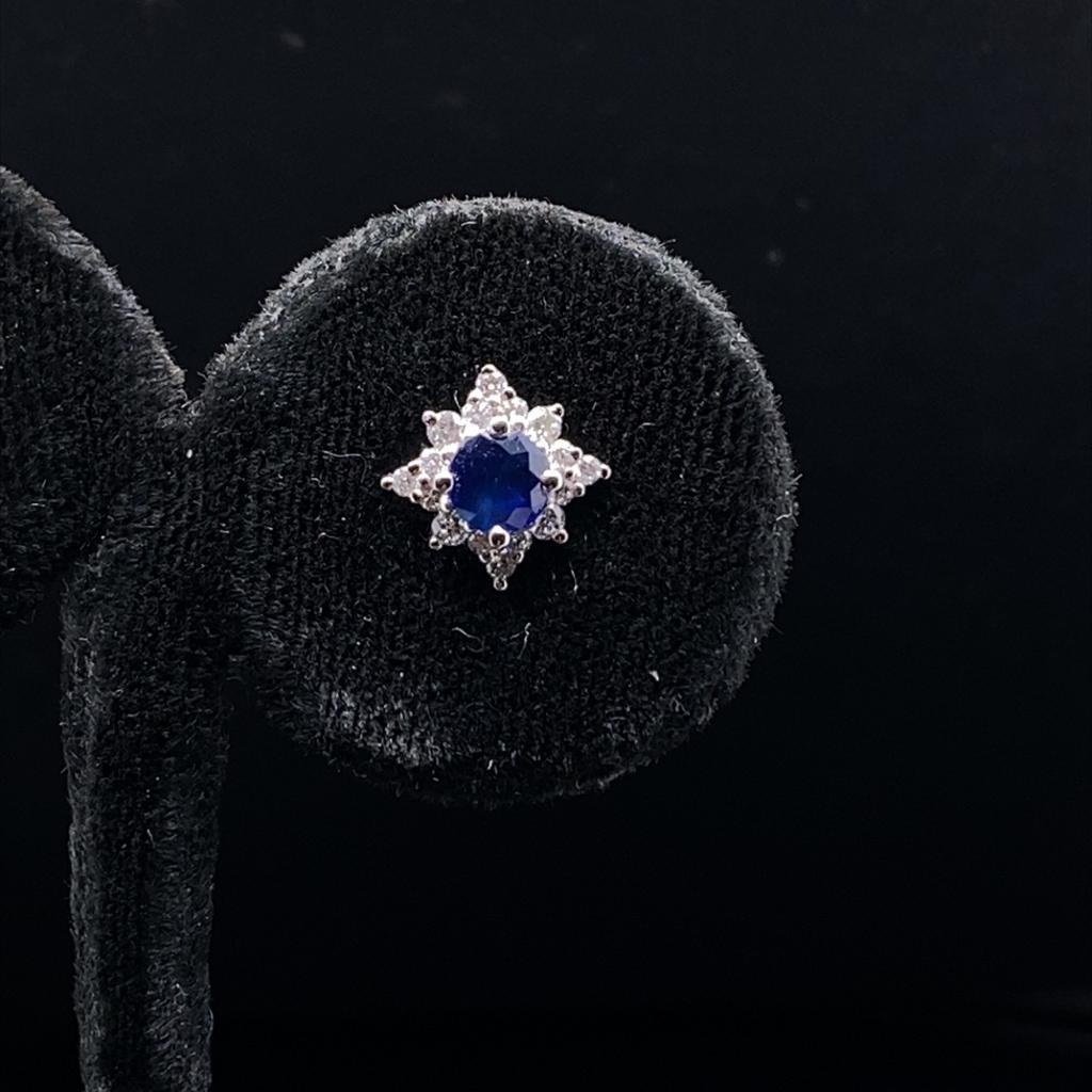 A pair of sapphire and diamond cluster stud earrings in 18 karat white gold.

Each of these stud earrings comprise of a beautiful round cut sapphire of fine quality surrounded by a star shaped claw set halo of sparkling round brilliant cut diamonds.