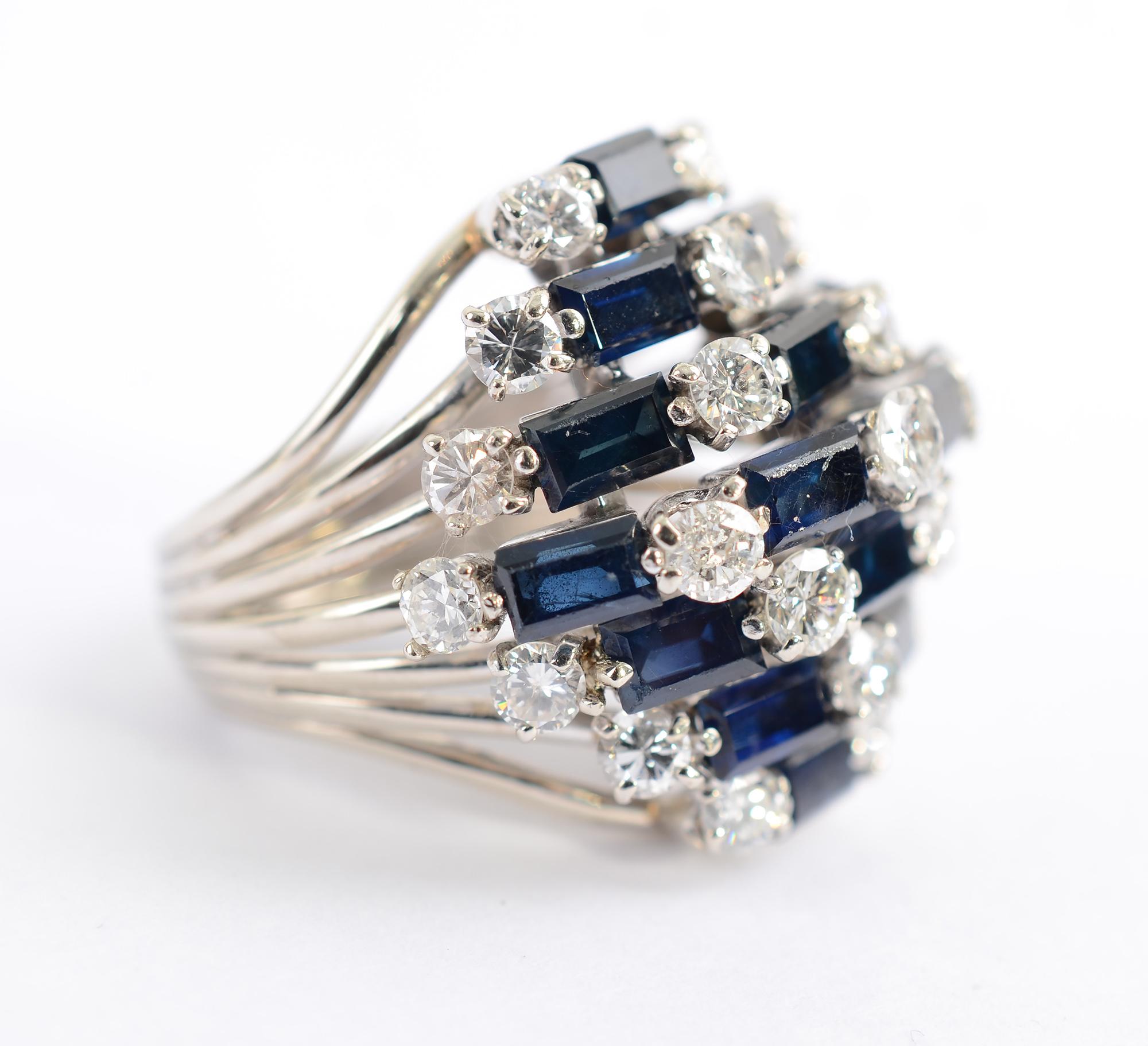 This stunning sapphire and diamond cluster cocktail ring was made in the 1950’s but  is timeless in design. It is made of 16 deep blue rectangular sapphires for a total of approximately 3 carats. The 23 round diamonds weigh approximately 4 carats.