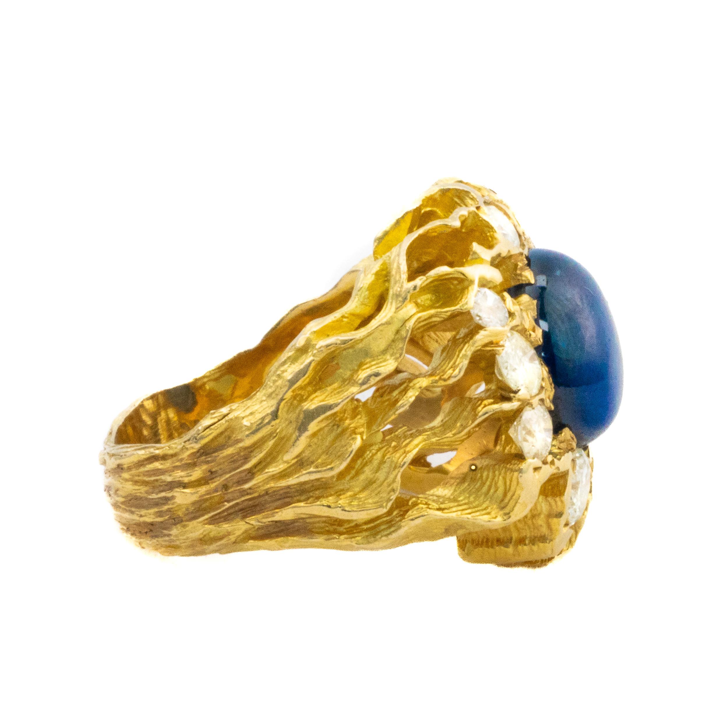 Saphir- und Diamant-Cocktailring

Beschreibung: Ein kühner Ring aus 14 Karat Gelbgold mit einem fesselnden Saphir-Cabochon von 5,25 Karat in der Mitte, der von 1,42 Karat funkelnden runden Diamanten umgeben ist. Die strukturierte Goldfassung