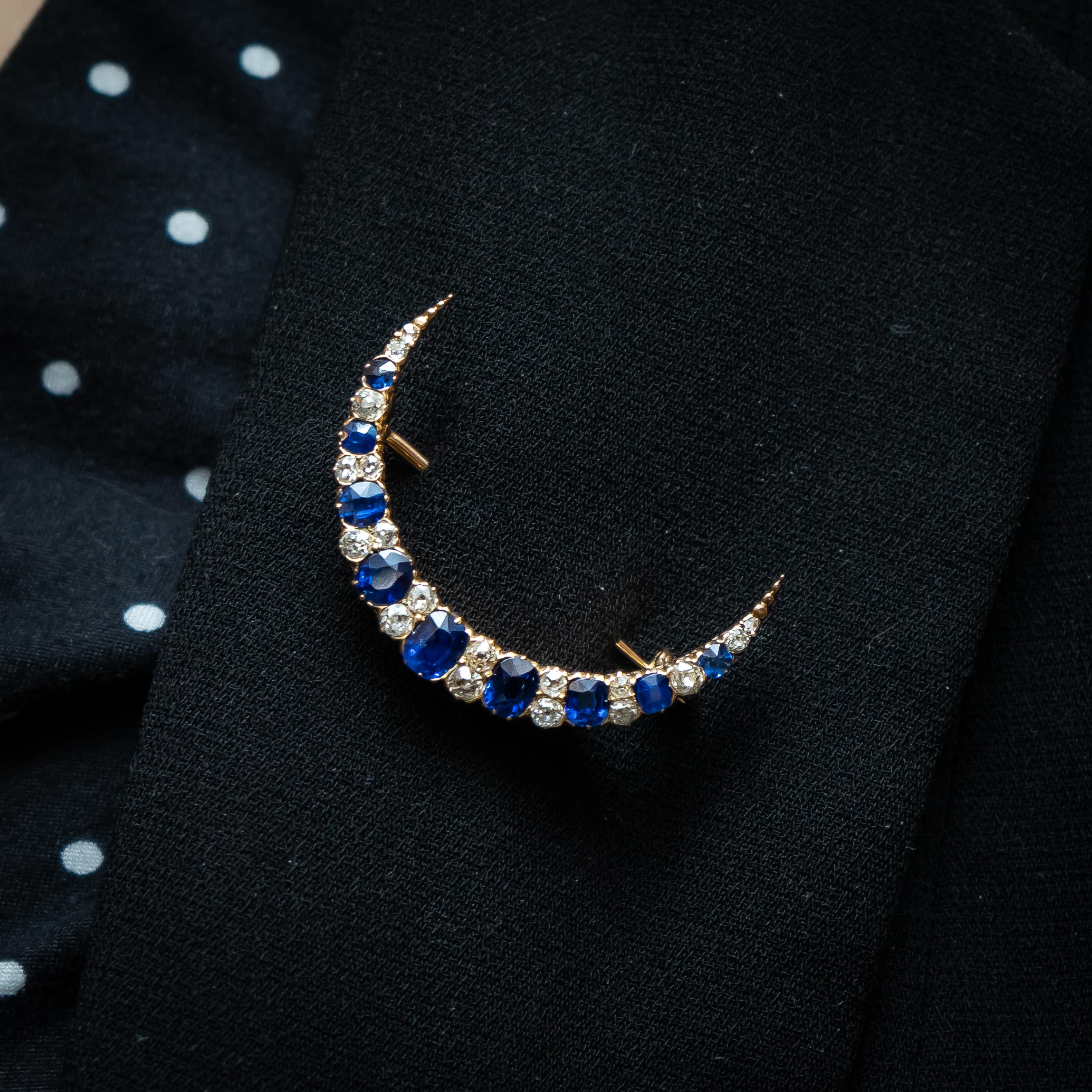 A Victorian sapphire and diamond crescent brooch, set with cushion shaped faceted sapphires, spaced with old-cut diamonds, in six pairs, two singles and two rose-cut diamonds, mounted in gold, in gallery strip claw settings, circa 1890.