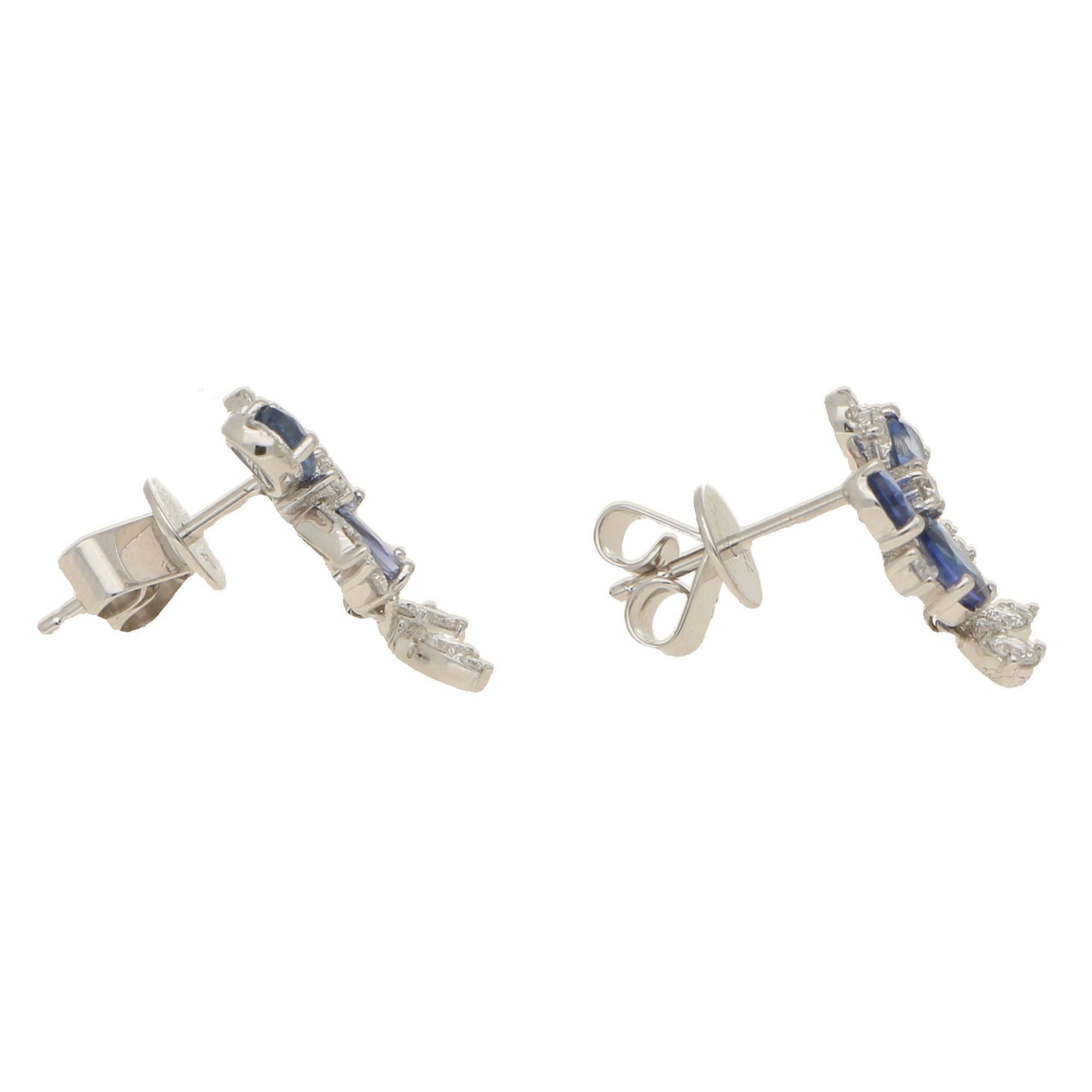 Sapphires 1.54cts, diamonds 0.49cts, G/H colour and VS clarity.
A sweet pair of sapphire and diamond daisy motif drop earrings set in 18 carat white gold. The main section of the earrings are comprised of three pear cut sapphires which  then