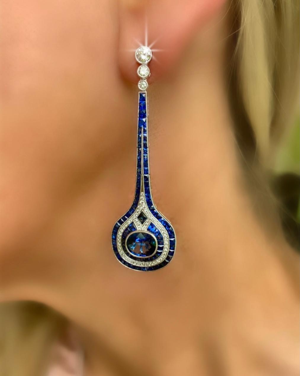 These are truly amazing! These gorgeous drop/dangle earrings will be loved by generations to come. They are expertly crafted in the style of art deco  with a center oval ceylon sapphire 4.07 ct tw. There is 1.0 ct tw in diamonds and another 7.06