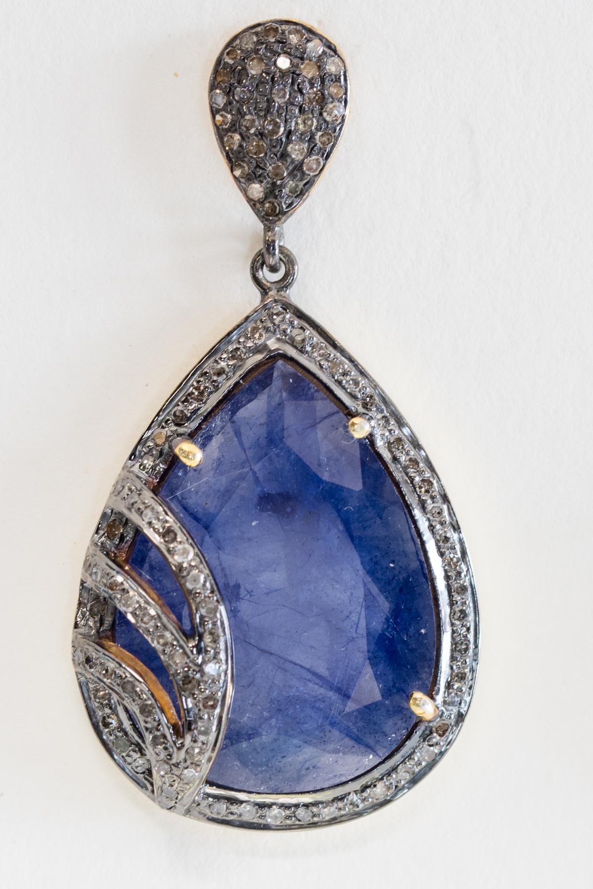 Pear-shaped, rosecut rock sapphires (as found in their natural state complete with imperfections) with diamond overlay and bordered in diamonds as well.  Set in an oxidized sterling silver with 18K gold post, for pierced ears.   Carat weight of