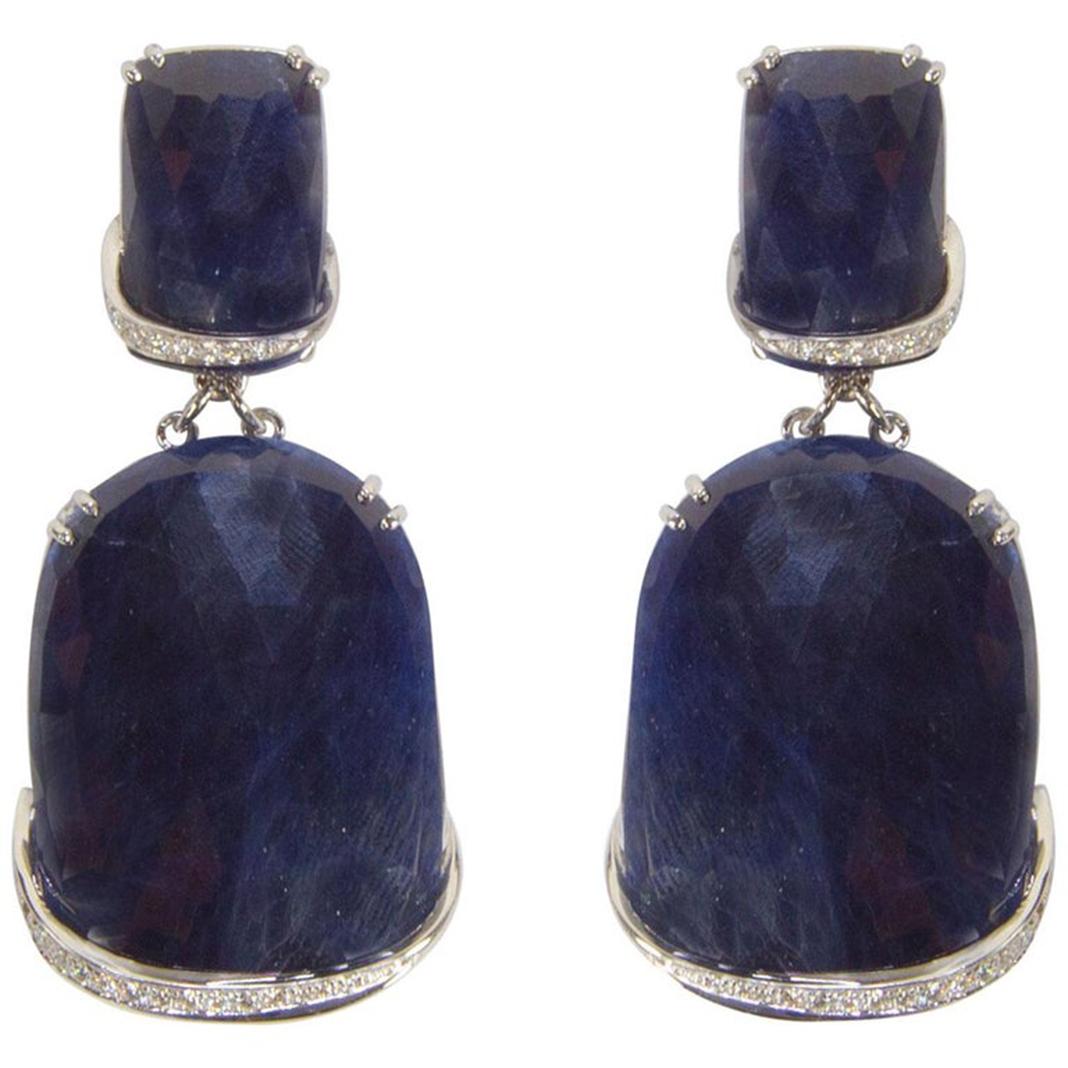 Sensational pair of faceted Slice Blue Sapphire Drop Earrings hand crafted in 18k white gold; featuring 2 faceted Slice Blue Sapphires; 30mm x 21mm each, suspended from 2 faceted Slice Blue Sapphires, approx. 16mm x 11mm each enhanced with brilliant