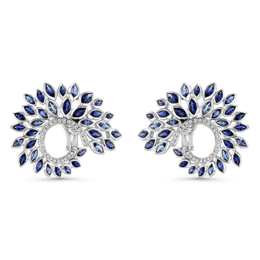 Composed of 18 karat white gold, 68 blue sapphires, and 52 white diamonds these glorious earrings make a true statement. Their ambiguous design resembles that of both a majestic plant and the wing of an angel or bird, and ultimately this intricacy