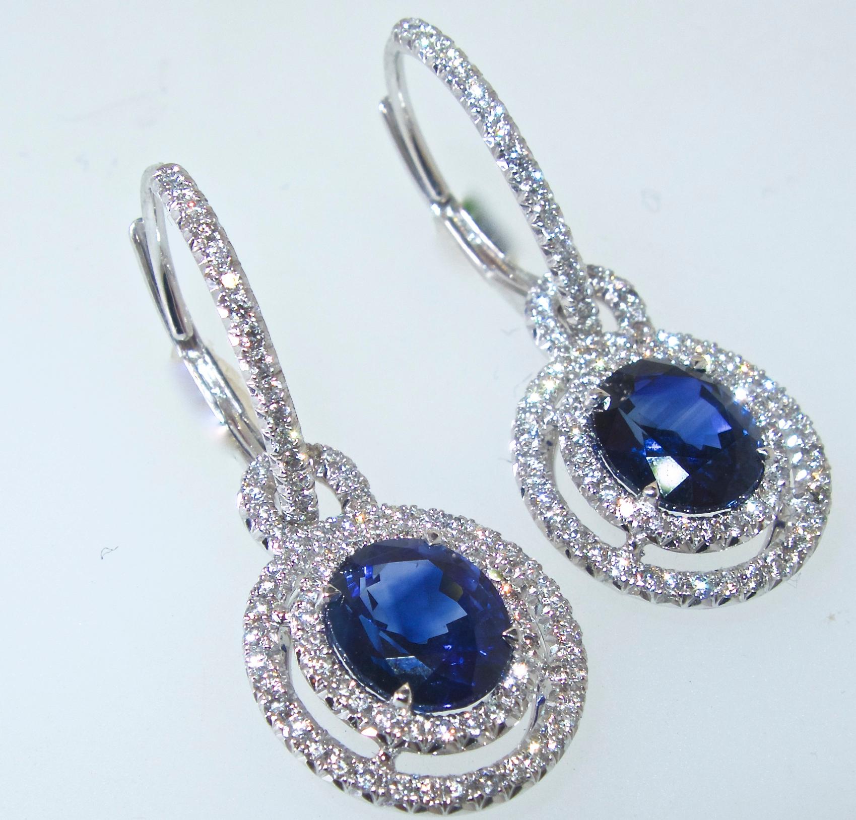 Sapphire and diamond earrings.  The natural vivid blue oval sapphires, are very fine quality, finely matched, with cutting as evident of their proportions, and the brightness of the stones.  The sapphires weigh 3.89 totally.  They are accented by