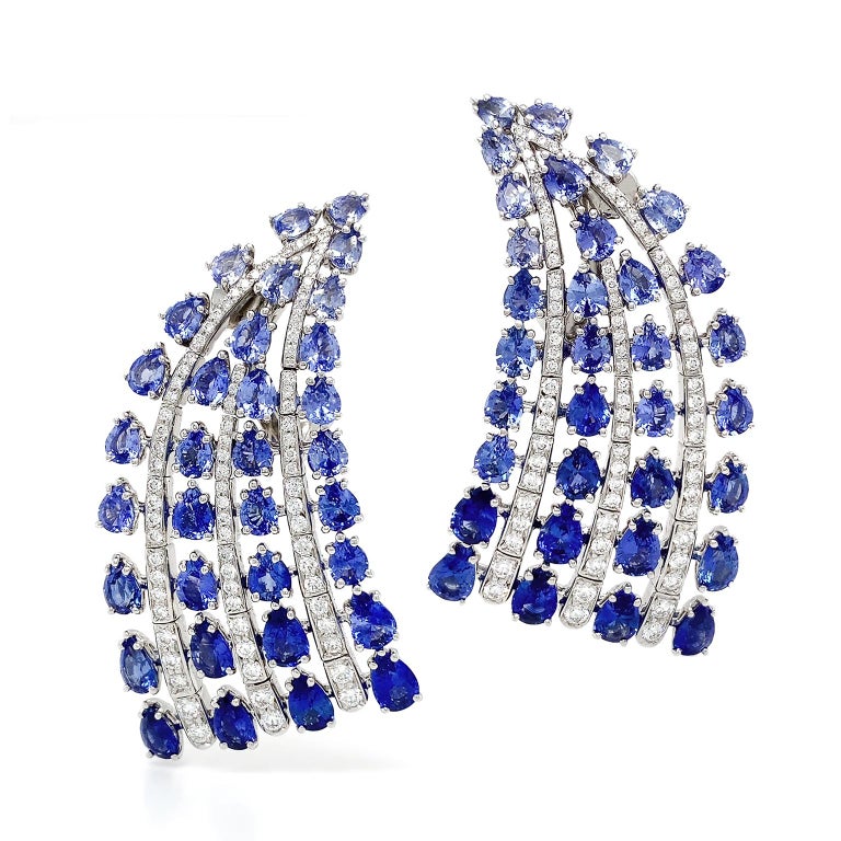 Jewels sweep down and glint in this fan motif. A tapered curve of pear-shaped sapphires is the base of the design. Within are three strands of brilliant cut diamonds and a row of sapphires on both sides, creating an alternated row of jewels. The