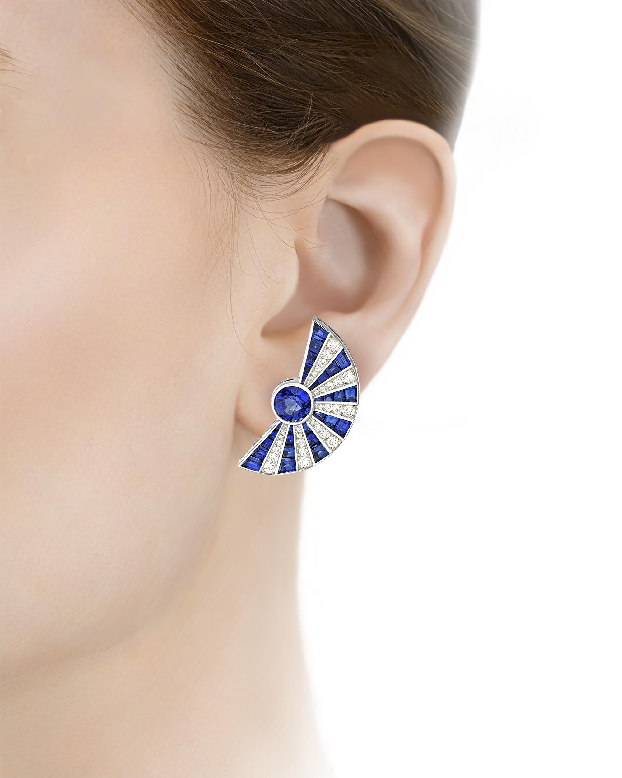 Radiating lines of deep blue sapphires totaling 7.33 carats and sparkling white diamonds totaling 0.80 carat resemble starbursts in these dramatic fan earrings. Set in 18K white gold.