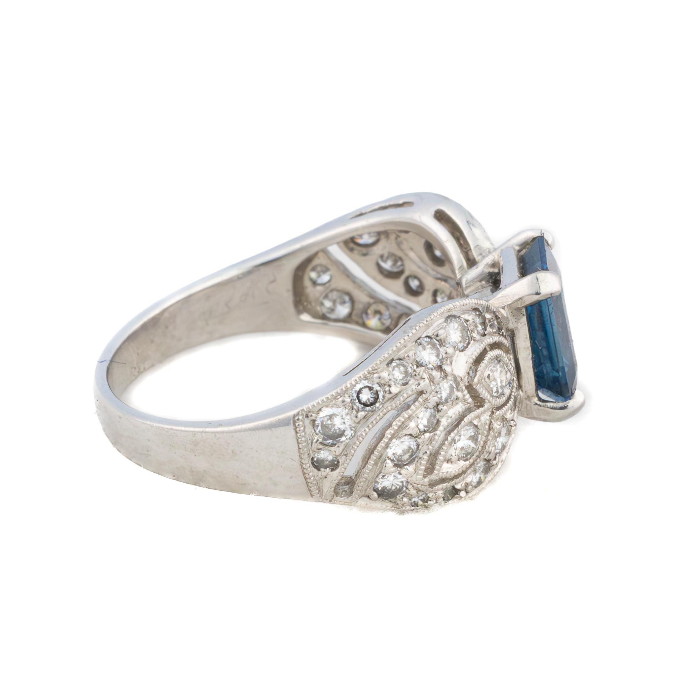 Sapphire and Diamond Filigree Ring

Description:
A finely crafted 14k white gold ring featuring a vibrant emerald-cut sapphire at its center, framed by an intricate filigree design. The shoulders are adorned with delicate diamond accents, adding