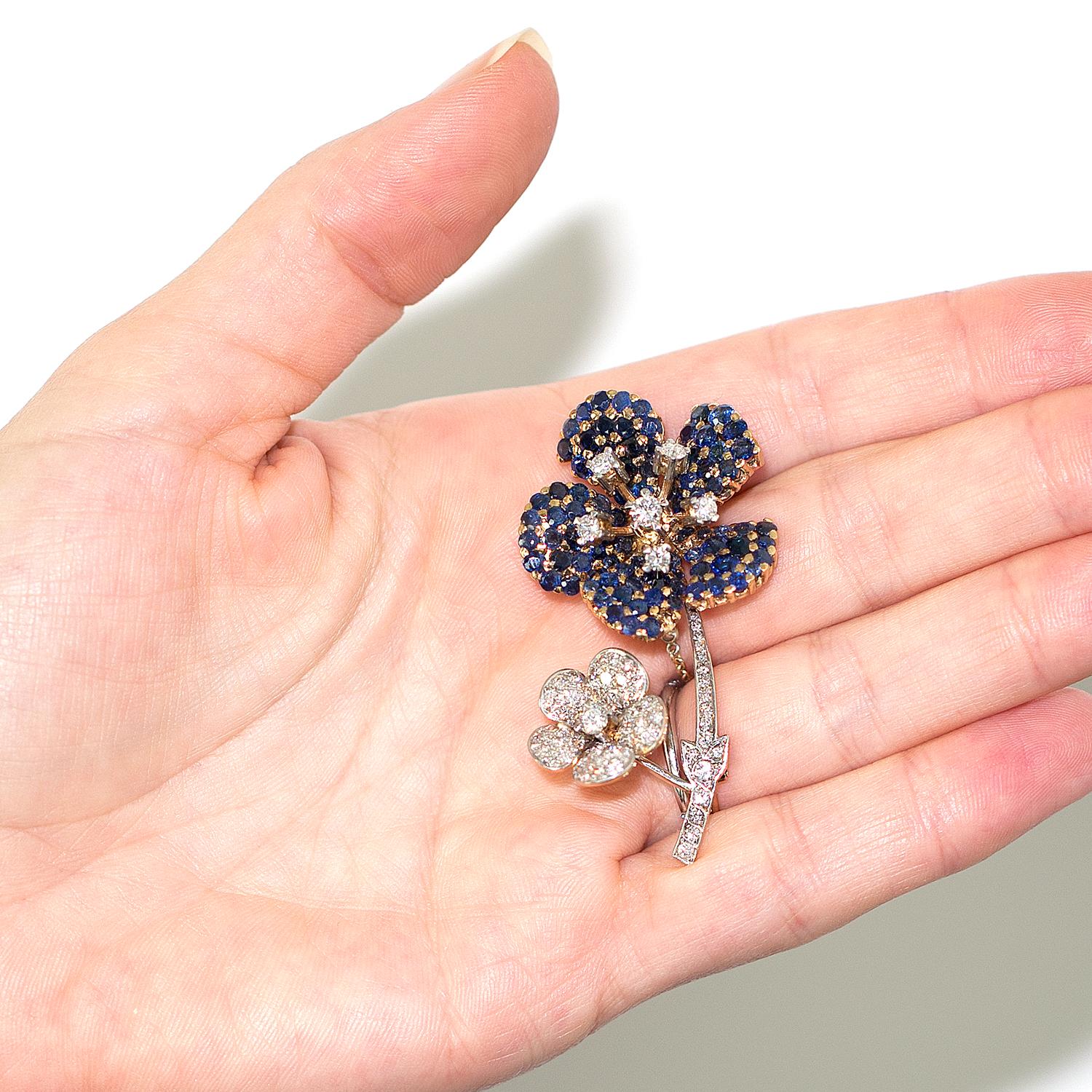 A beautiful floral diamond and sapphire brooch, set in 18 karat white & yellow gold. The diamonds are G in color and VS in clarity, with an approximate total weight of 2 carats.  