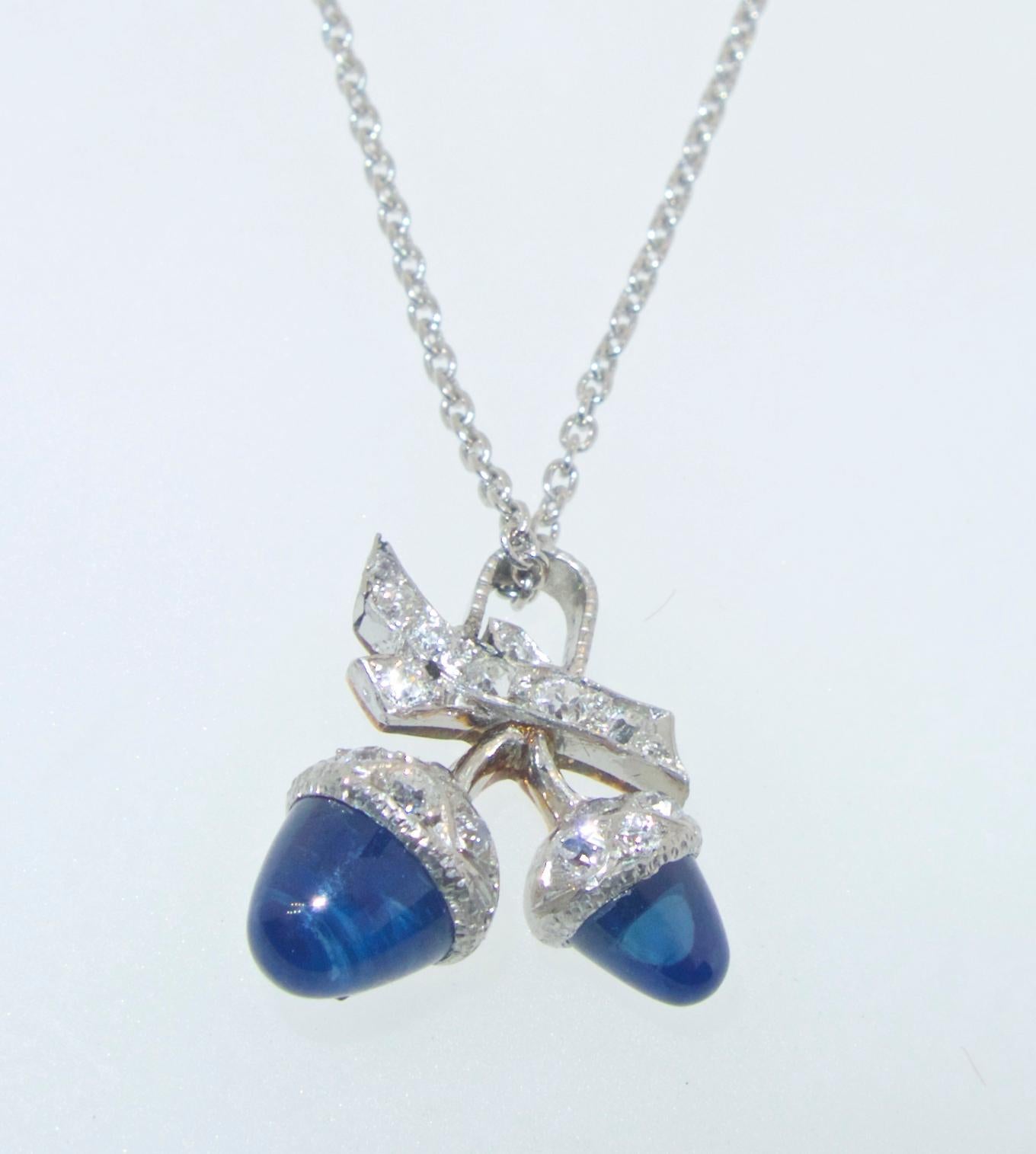 Sapphires and diamonds set in platinum and gold in a petite floral and leaf motif.  This charming piece can be either a pendant or a charm.  Made in the first quarter of the 20th century, the sapphires are a deep pure blue and the diamonds add a