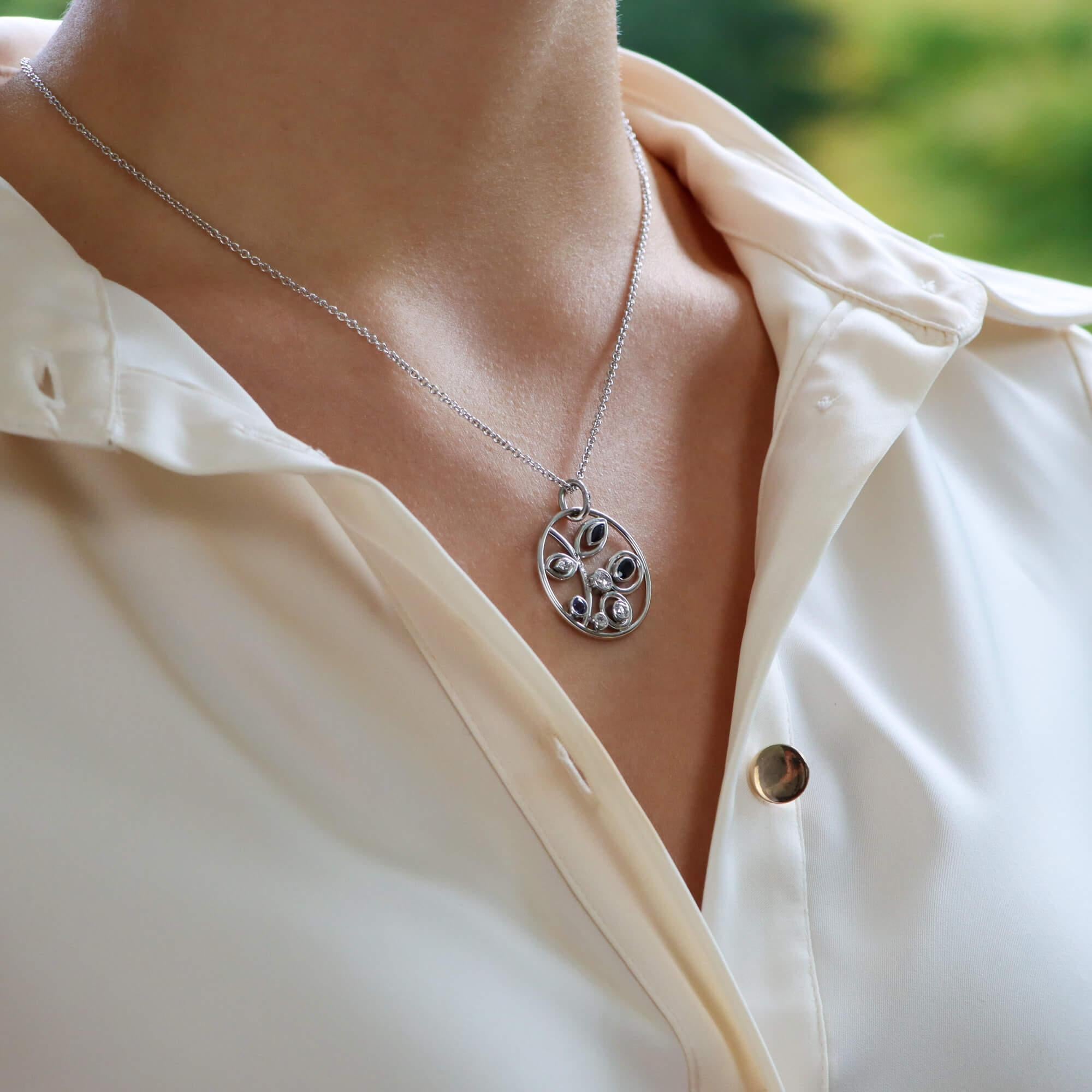 Un pendentif circulaire ajouré moderne et amusant avec des motifs floraux sertis en or blanc 18 carats. 

Le pendentif est conçu comme un cercle ajouré avec une gerbe de feuillage à l'intérieur. La tige est sertie de diamants taillés en rose, tandis