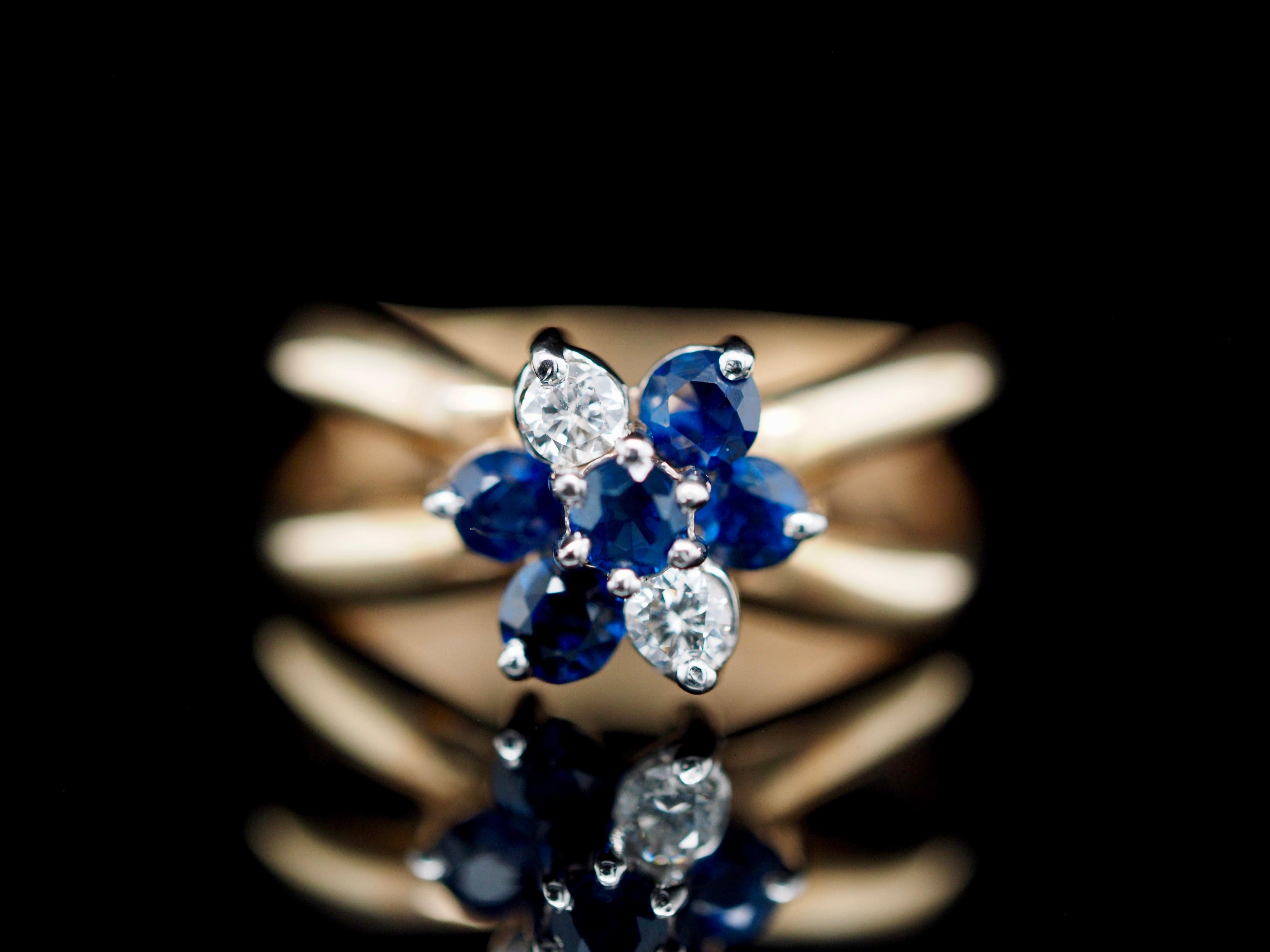 This stunning diamond and sapphire ring makes the perfect statement. Its royal blue sapphires and touch of round brilliant diamonds gives the perfect pop of sparkle! The timeless flower halo design makes the perfect treat to yourself or will make