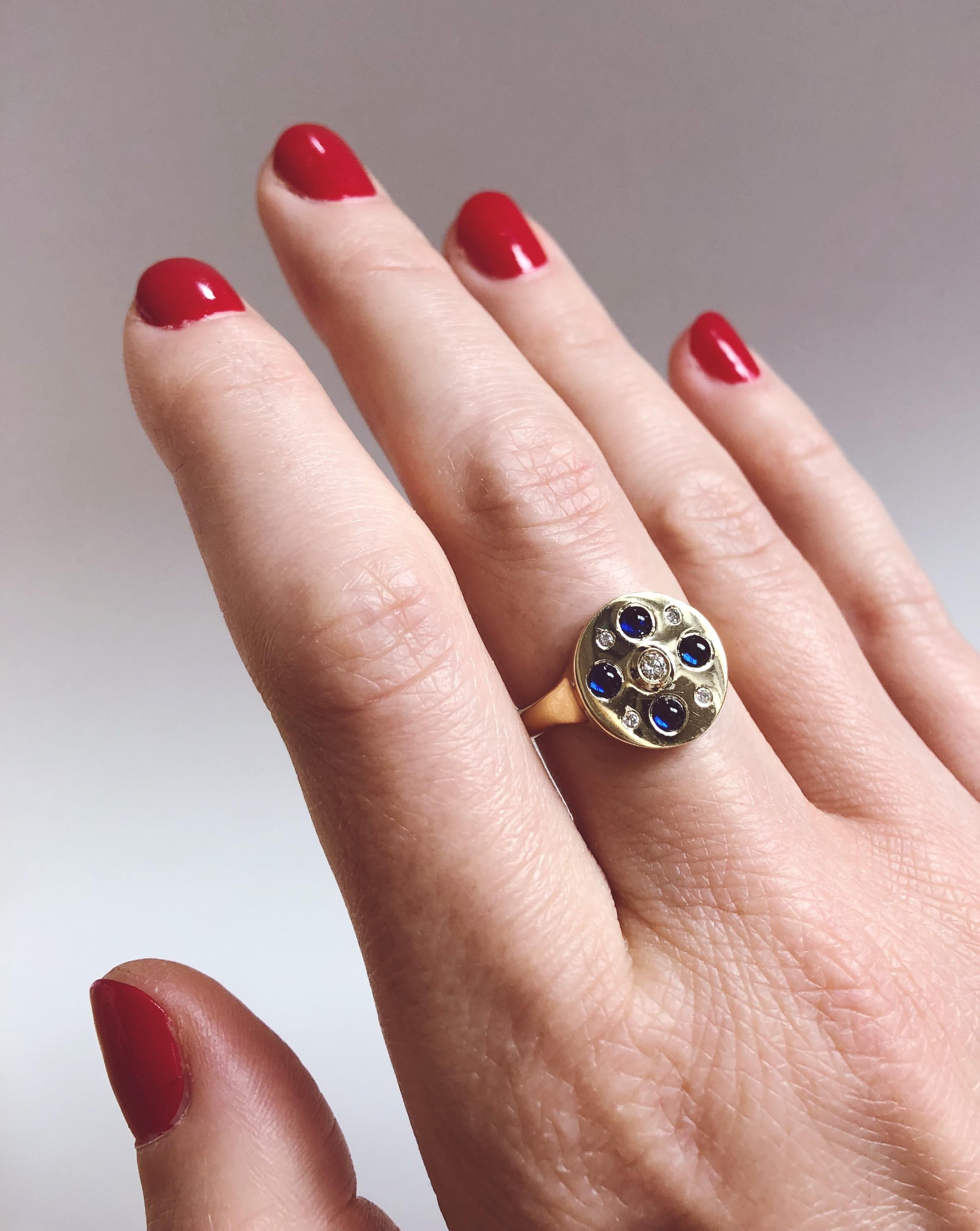 The Demeter Ring with Sapphire from modern fine jewelry house, Baker & Black. A geometric arrangement of gems give this understated cocktail ring a distinctly graphic edge, offset by the soft sapphire cabochons.

• sapphire cabochons, measuring 4mm