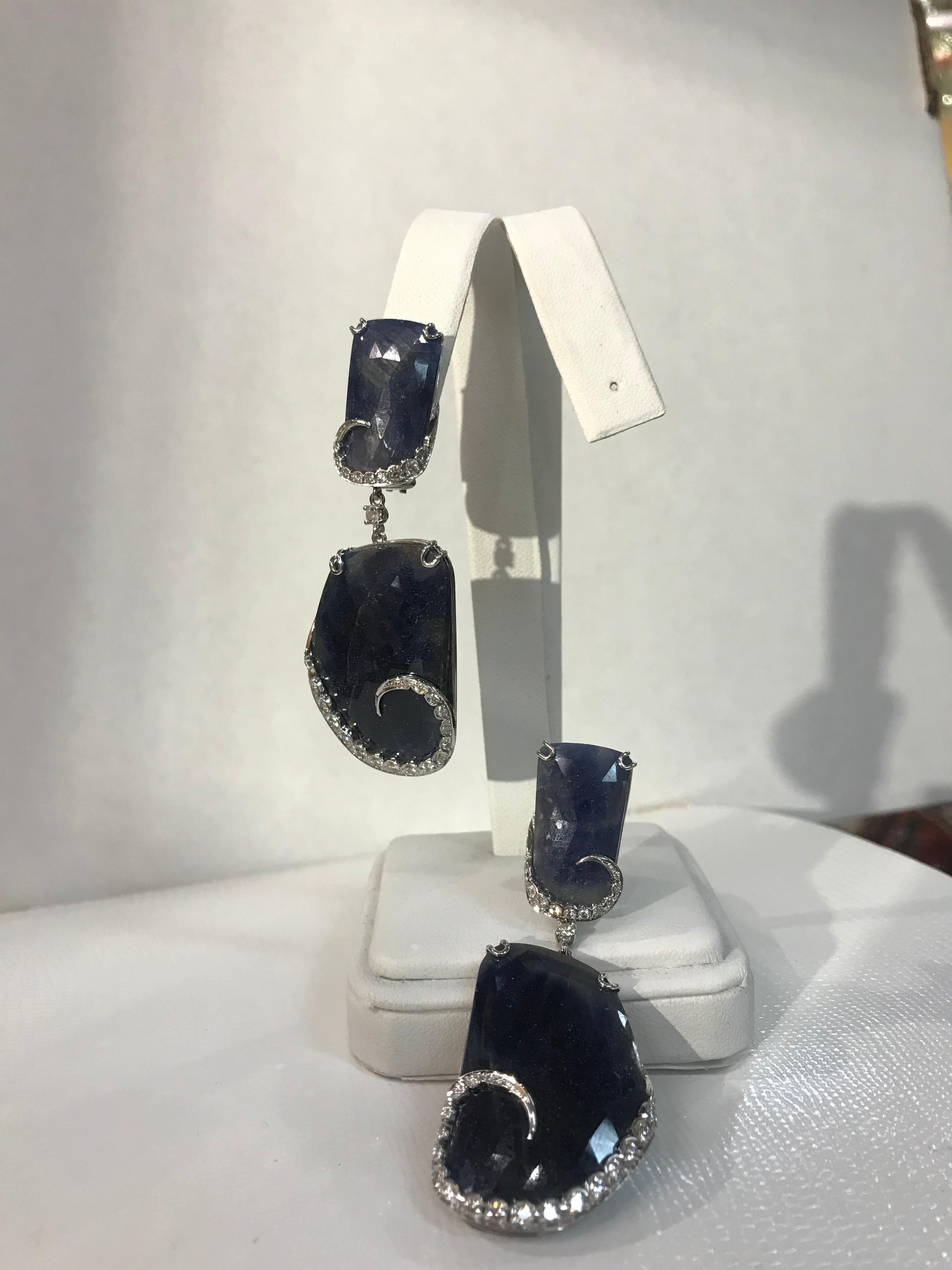 Sensational pair of faceted Slice Blue Sapphire Drop Earrings hand crafted in 18k white gold; featuring 2 faceted Slice Blue Sapphires; 30mm x 21mm each, suspended from 2 faceted Slice Blue Sapphires, approx. 16mm x 11mm each enhanced with brilliant