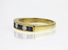 Sapphire and diamond half eternity channel set ring in 18ct yellow gold