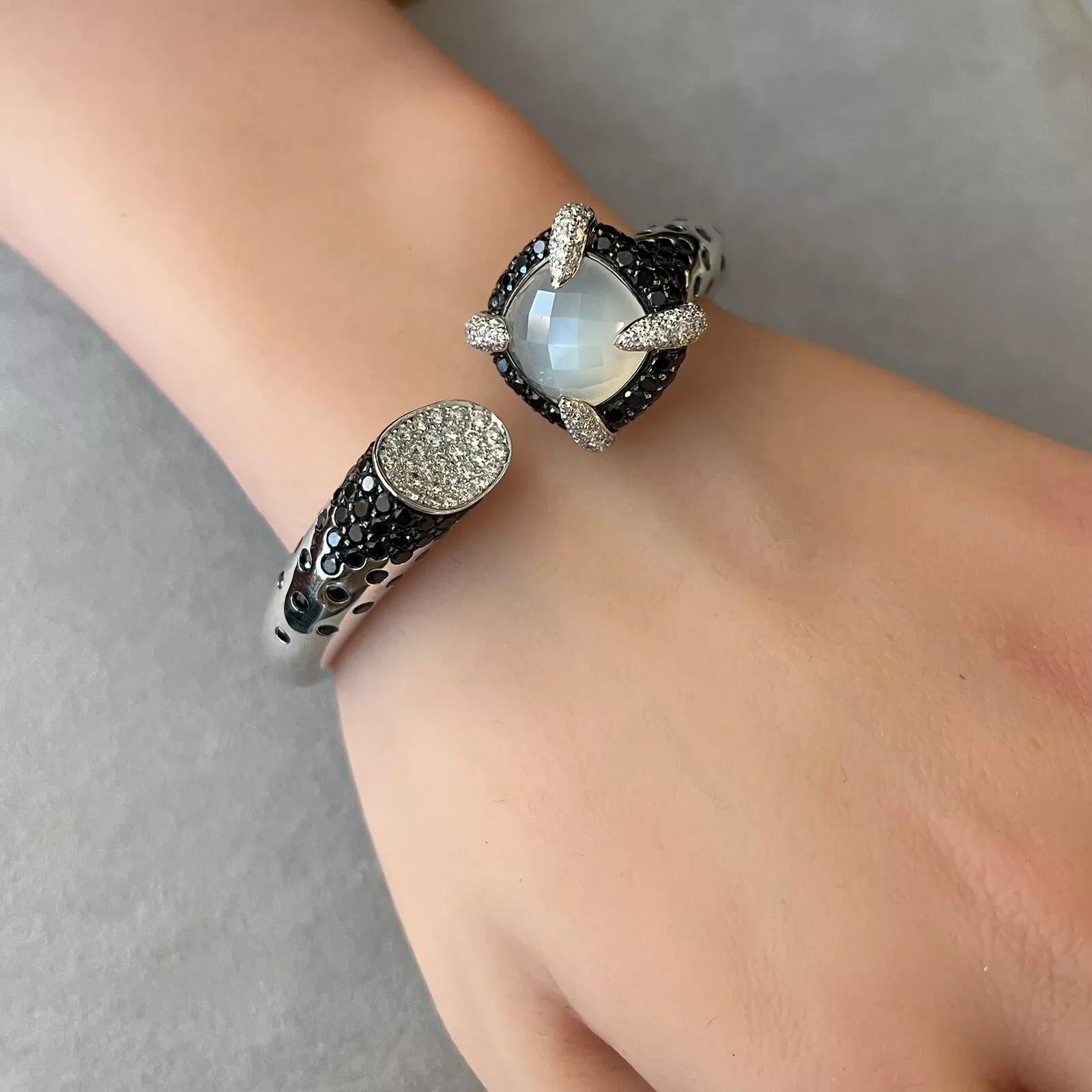 Bracelet à charnière en saphir et diamant en or blanc 18k

Le bracelet en diamant et saphir présente des saphirs foncés et des diamants blancs naturels en pavage dans un bracelet à charnière avec une pierre naturelle à facettes au centre, le tout