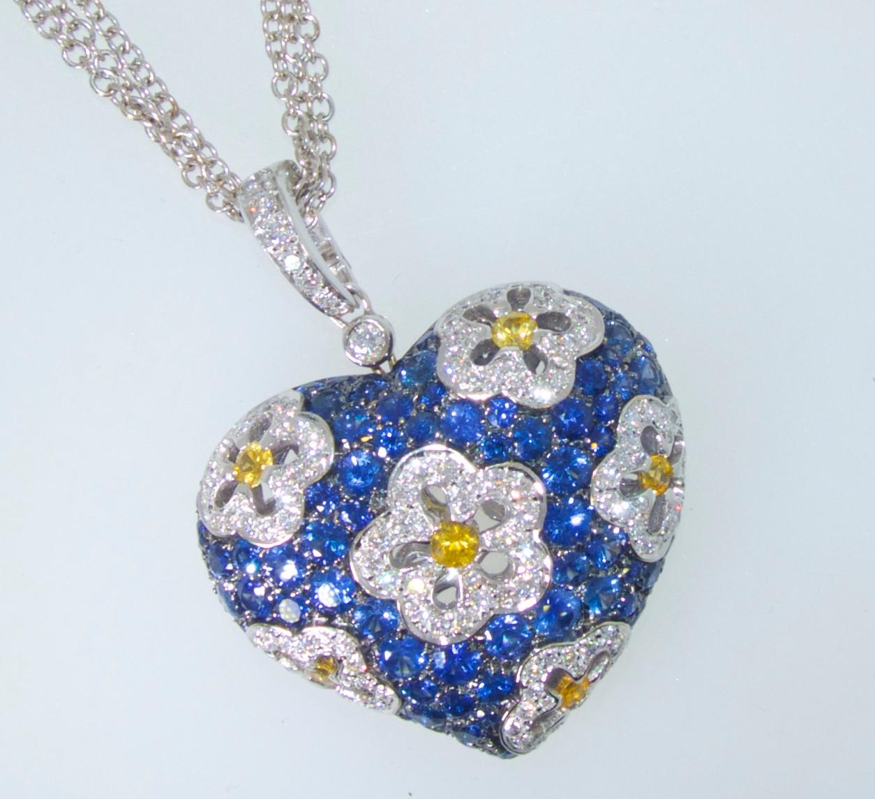 Sapphire and diamond large heart motif pendant necklace with pave set fine natural blue sapphires weighing approximately 5.5 cts., and yellow sapphires weighing approximately .5 cts.  The fine white diamonds (G/H, VS) weigh approximately 2.25 cts. 