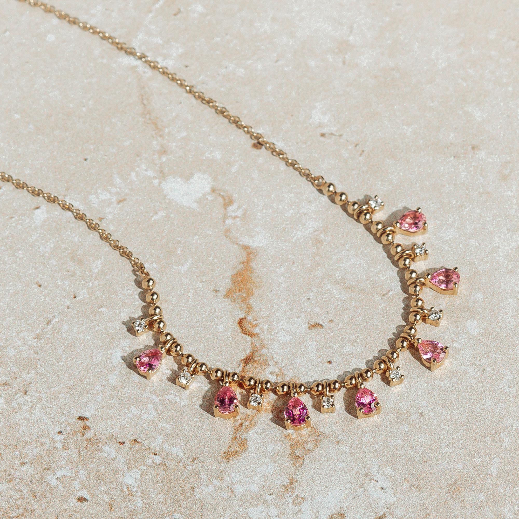 Une étonnante et délicate série de poires en saphir rose entrecoupées de diamants ronds et de perles d'or. Réalisé en or jaune 14 carats. Ce collier comporte 8 diamants ronds de 0,15 ctw et 7 saphirs roses en forme de poire de 1,35 ctw. S'ajuste à
