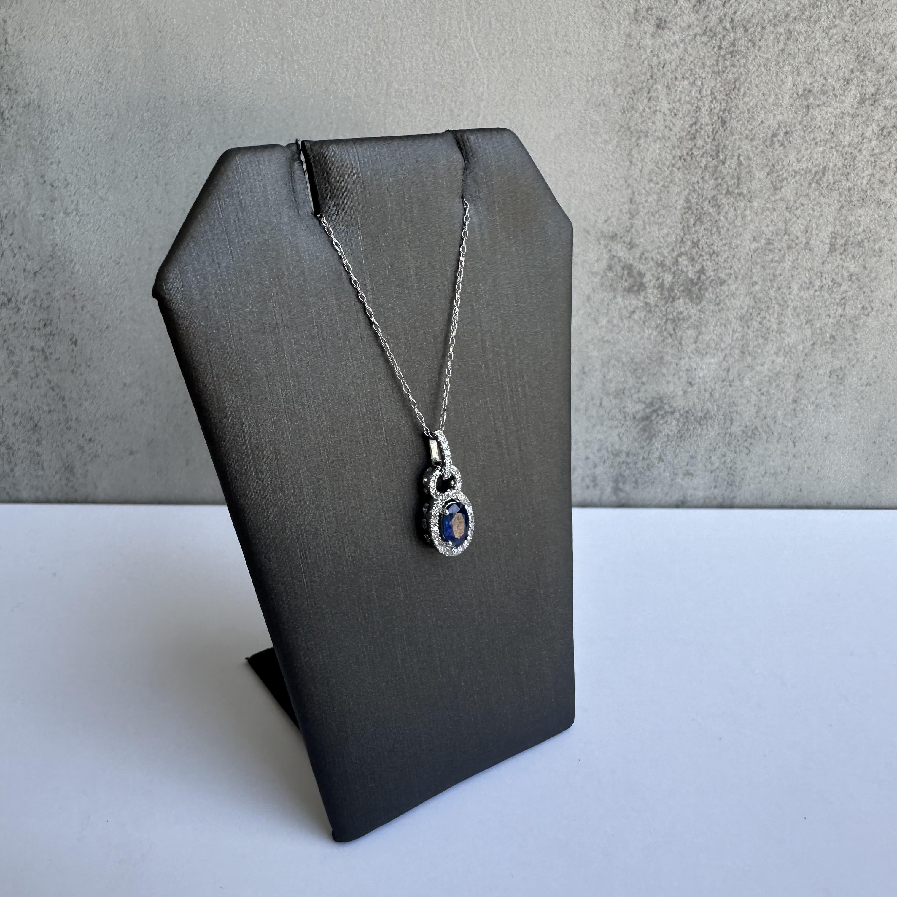 Enhance your jewelry collection with this exquisite Sapphire and Diamond Necklace in 10kt White Gold. Featuring a 6x4mm oval sapphire and 0.14 carats of GH SI natural round single cut diamonds, this necklace combines timeless beauty with modern