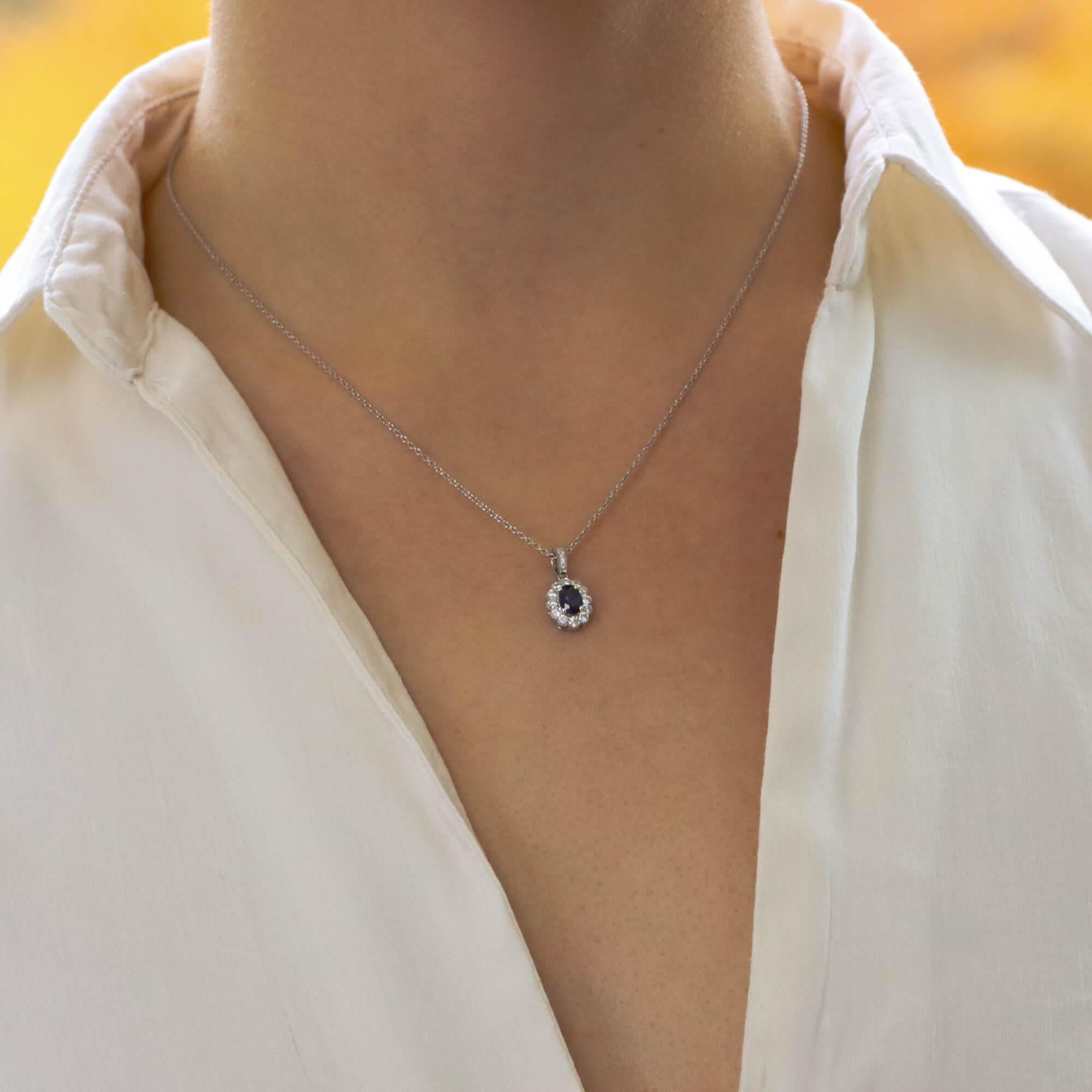 A beautiful oval cut sapphire and diamond cluster pendant set in 18k white gold.

The pendant is centrally set with a beautiful coloured blue oval cut sapphire which is surrounded by 12 sparkly round brilliant cut diamonds. The pendant hangs from a