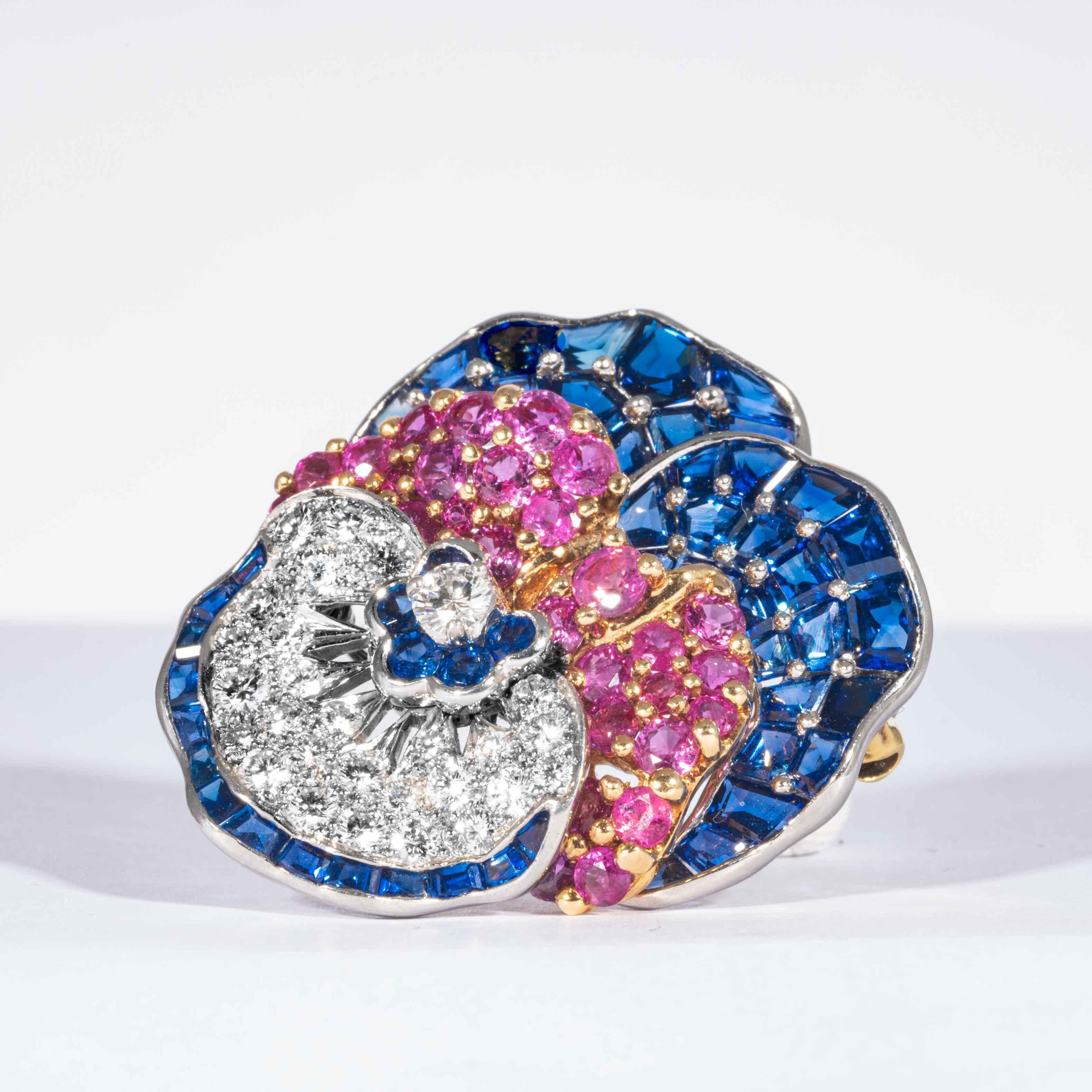 Blue, fancy pink sapphires and diamonds are set in 18kt yellow gold and platinum in this whimsically classic floral pansy pin.  Consisting of 48 mixed cut blue sapphires, 5 round cut blue sapphires, 30 round cut fancy pink sapphires, and 28 round