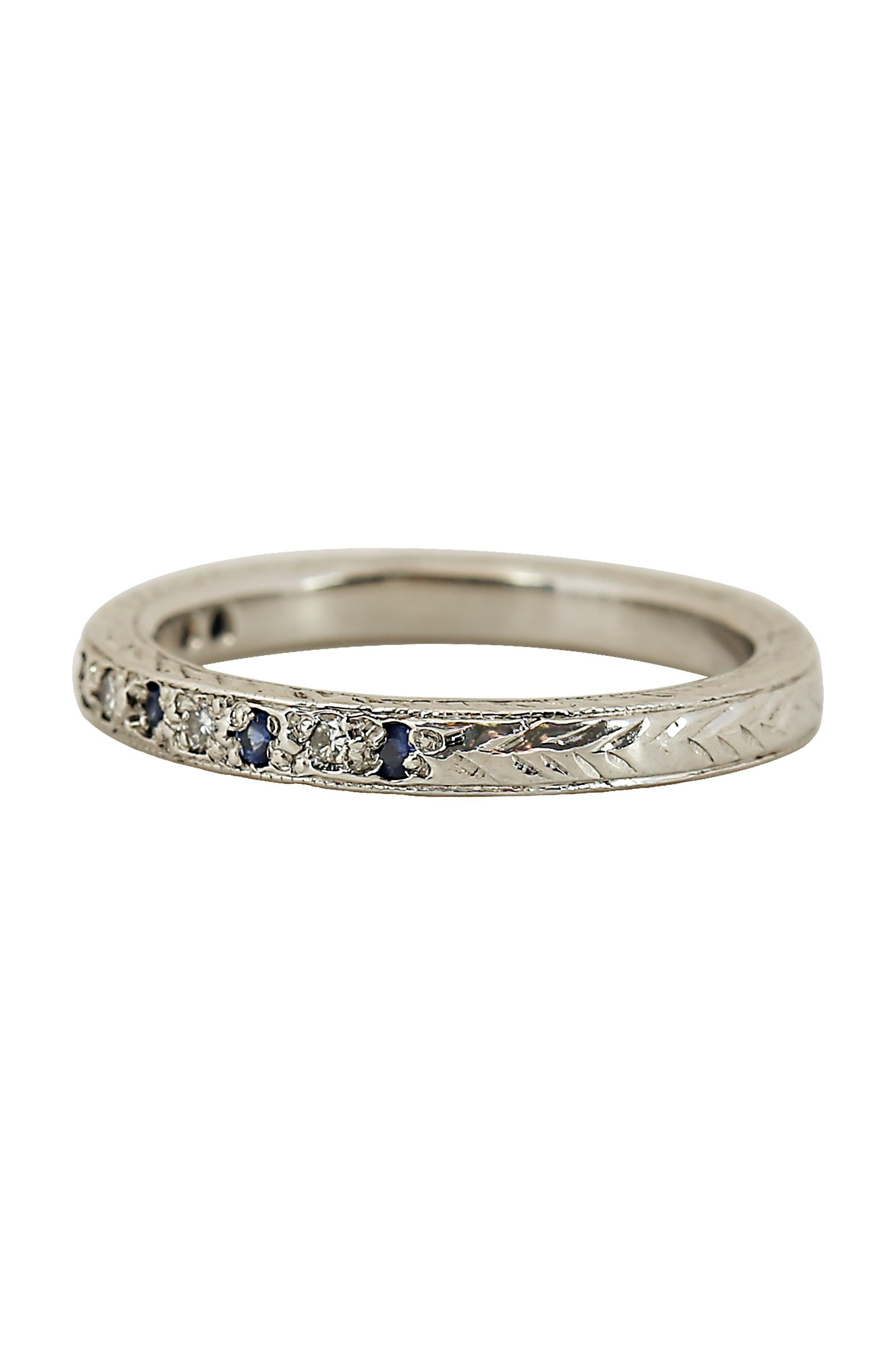 A lovely vintage band of alternating round sapphires and diamonds in a delicately engraved band. Total gemstone weight is .12 carat. Currently size 5.5.

