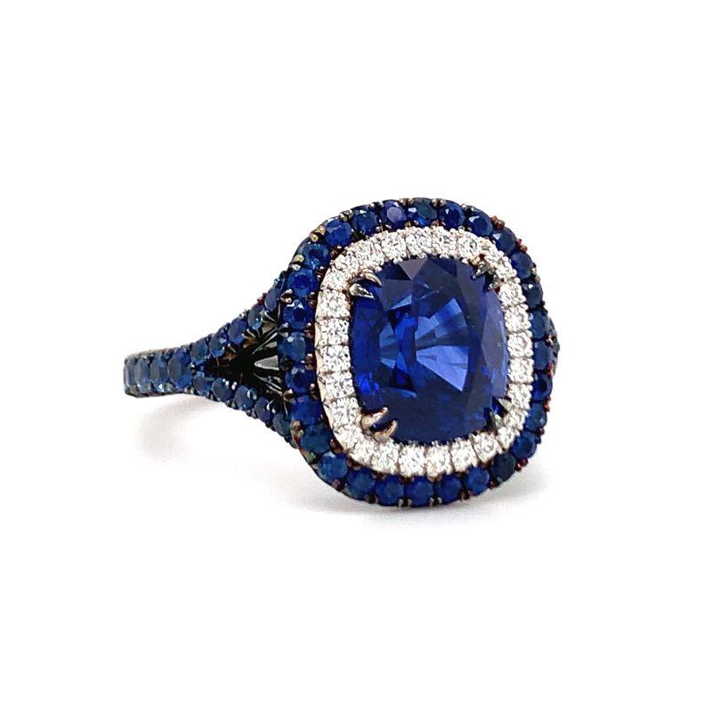 One sapphire and diamond blackened platinum finish ring by OMI centering one prong set, cushion cut deep royal blue sapphire weighing approximately 2.75 ct. with sapphire and diamond accents. From the Omi Prive Duet collection. Retails for