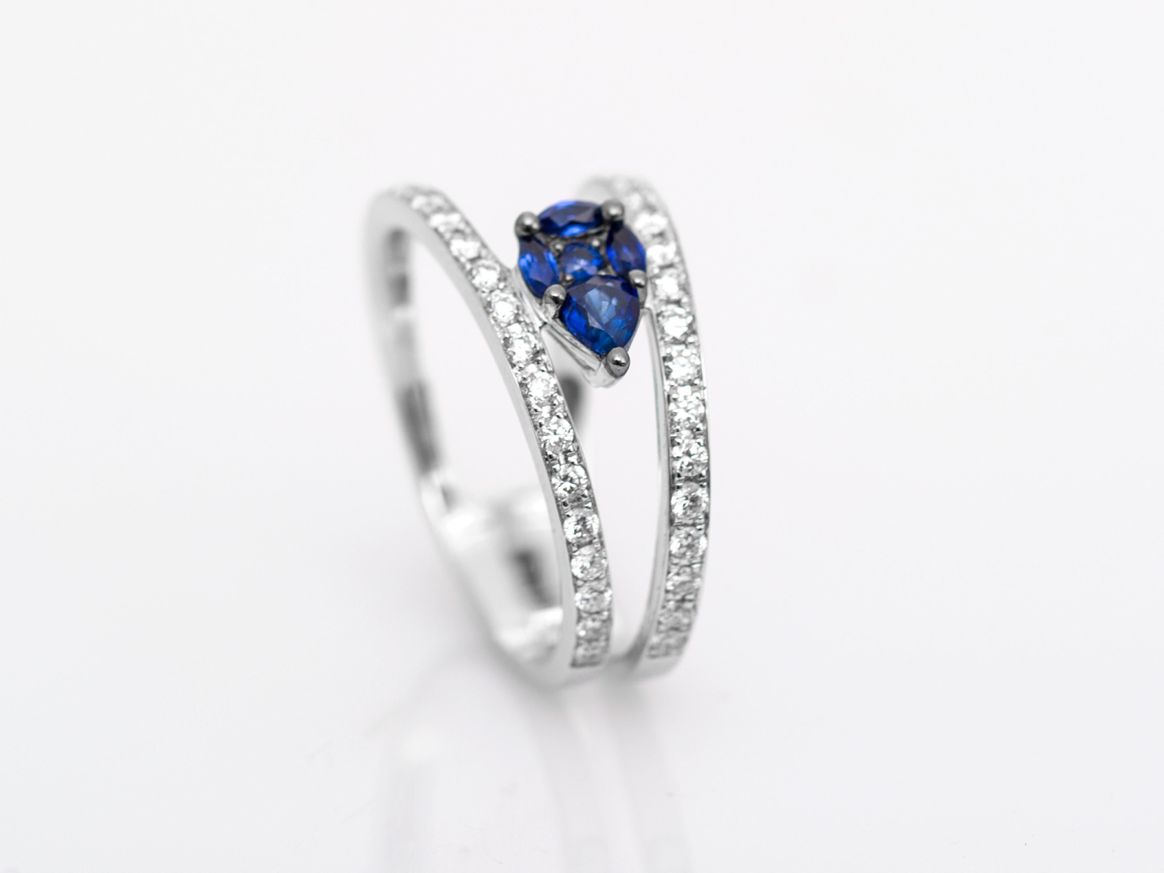 5 sapphires pavé-set in the centre to create an illusion of a larger pear shaped sapphire in-between bands of brilliant cut stones. The piece is handmade with delicacy.