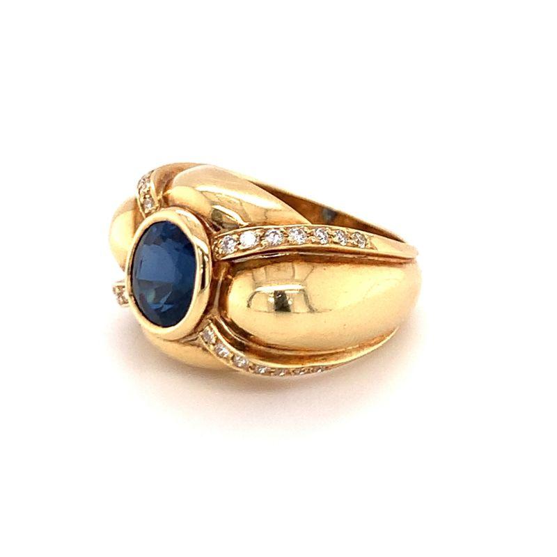 Sapphire and diamond ring in 18K yellow gold from the 1960s centering one round, deep blue sapphire weighing 2.75 ct. and further enhanced with diamond melee and puffed gold shoulders. Shimmering, grand, divine.

Additional information:
Metal: 18K