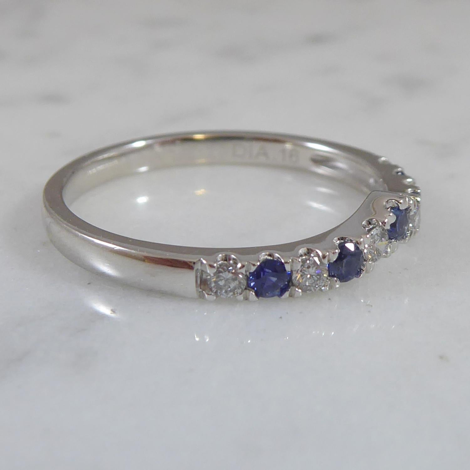 A lovely sapphire and diamond set new and unworn band in a small V shaped wishbone design.  The ring is so perfectly adaptable to wear as a wedding band, with the V sitting around a solitaire, or as a modern dress ring to wear alone or as part of a
