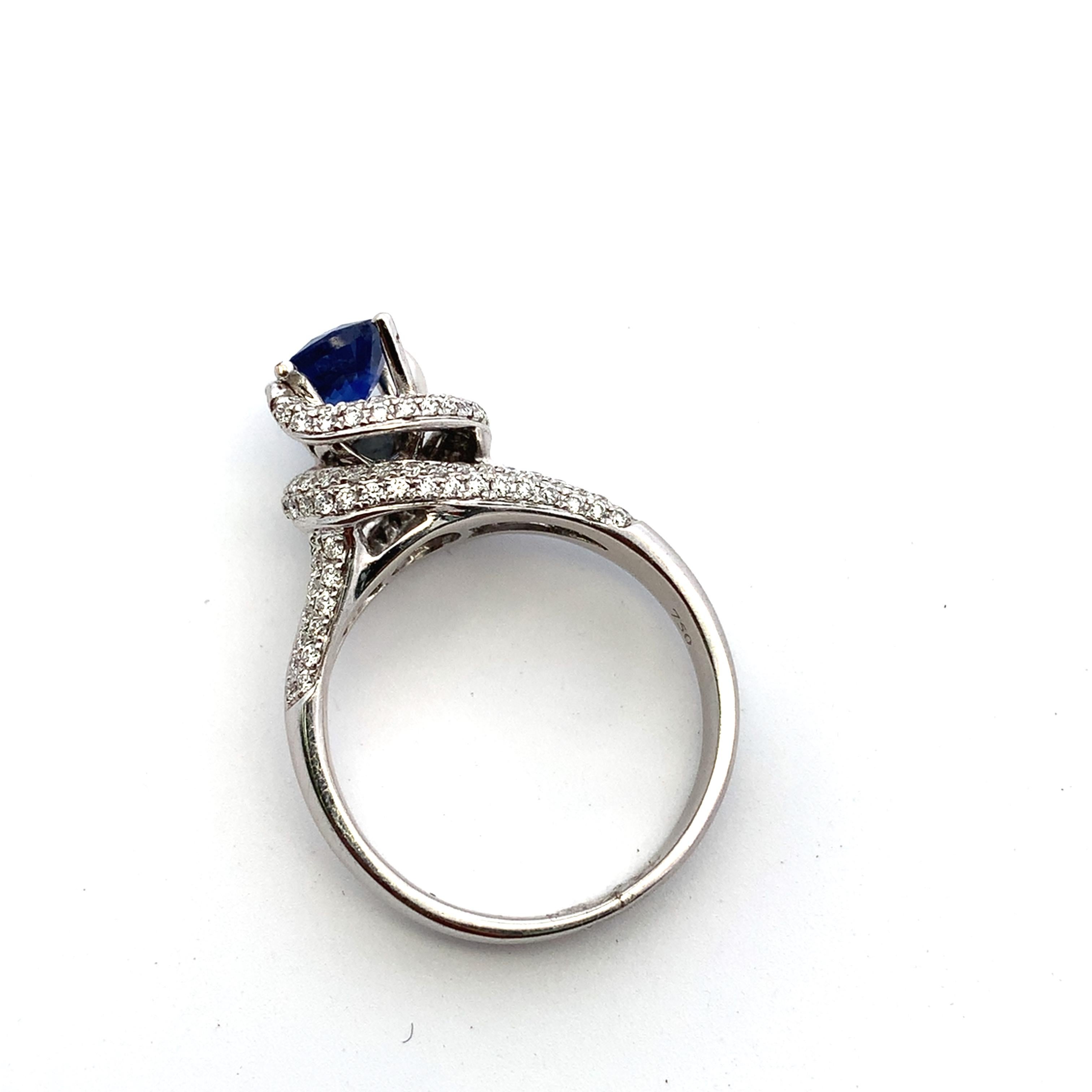 Discover the allure of this stunning blue sapphire and diamond twisted halo ring, featuring a vibrant blue sapphire round cut gemstone that captures the essence of elegance. Crafted in 18k white gold with precision, the sleek band complements the