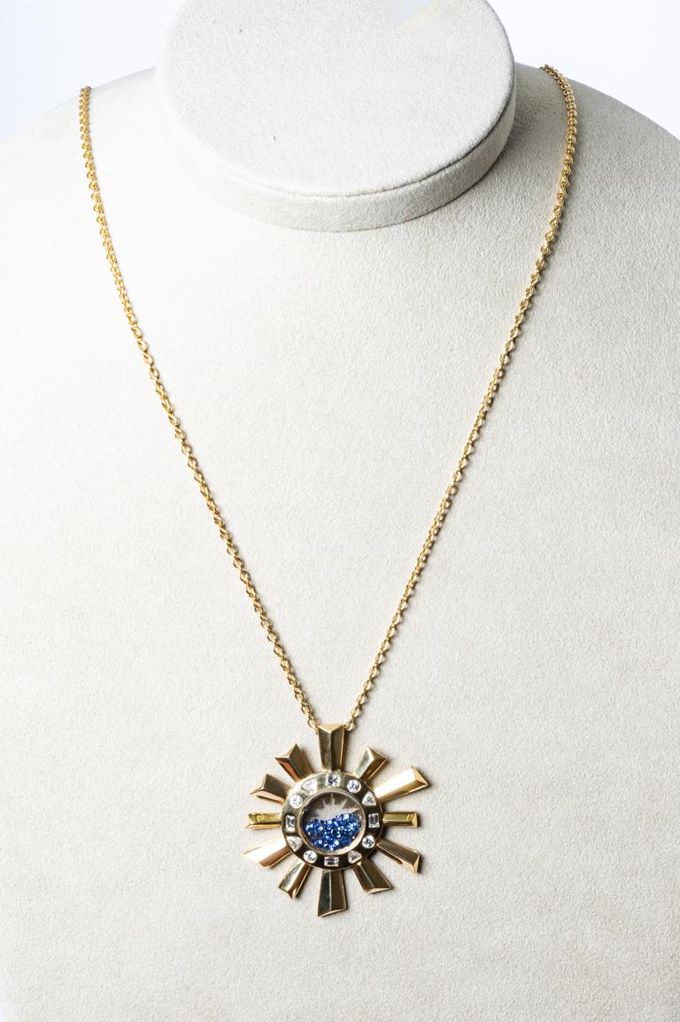 Zénith Necklace long chain surmounted by a yellow gold pendant in sun shape.
The pendant is free on the chain.
Diamonds of different sizes round, priangle and princess (square) weigh 1.31 carats in G/vs color. Inside the sapphires that can move and