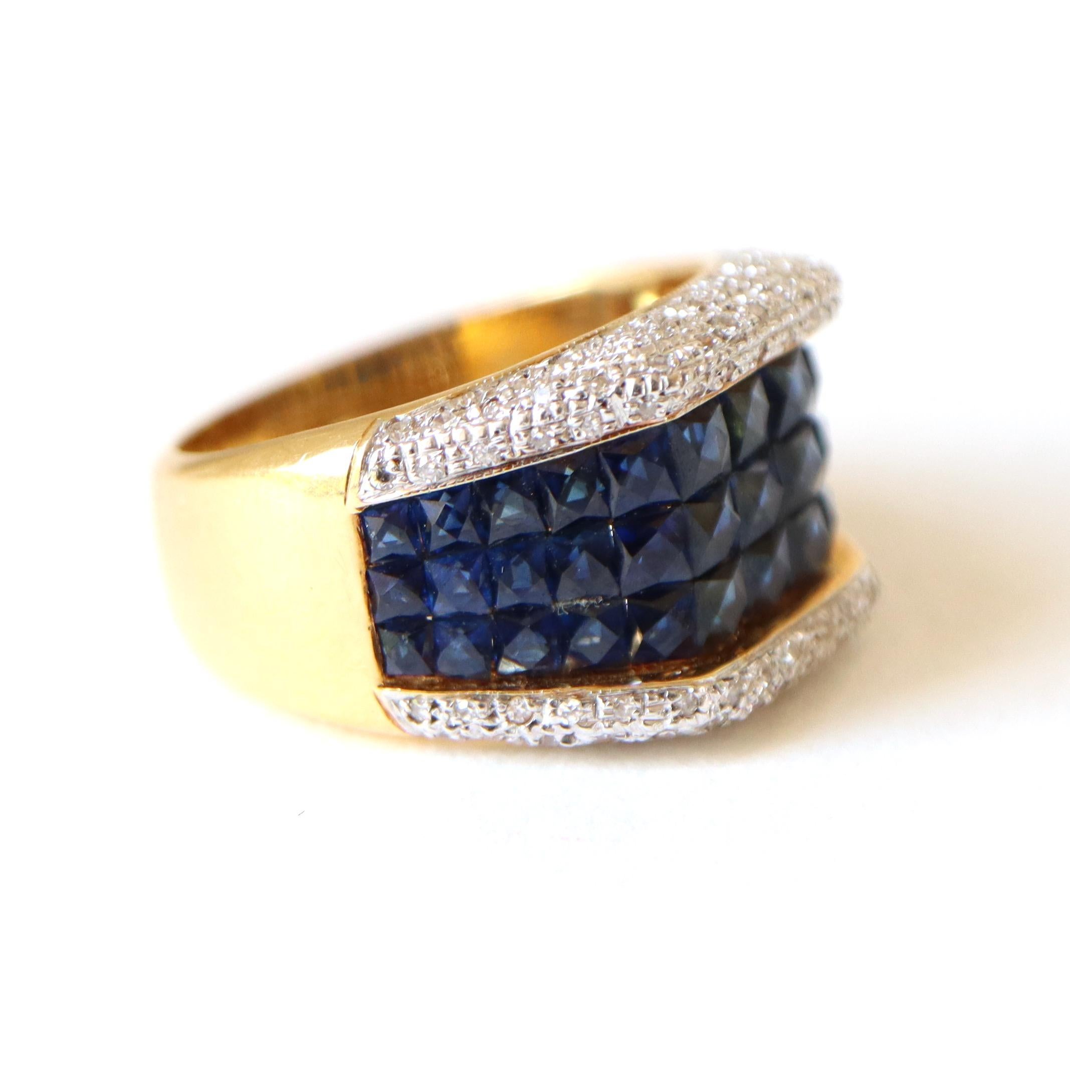Bague Brilliante en or jaune 18 kt sertie de 39 saphirs calibrés pour un poids total d'environ 8 carats (7,99) dans une monture invisible mystérieuse encadrée de part et d'autre d'un anneau en or blanc 18 kt serti de diamants taillés en brillant