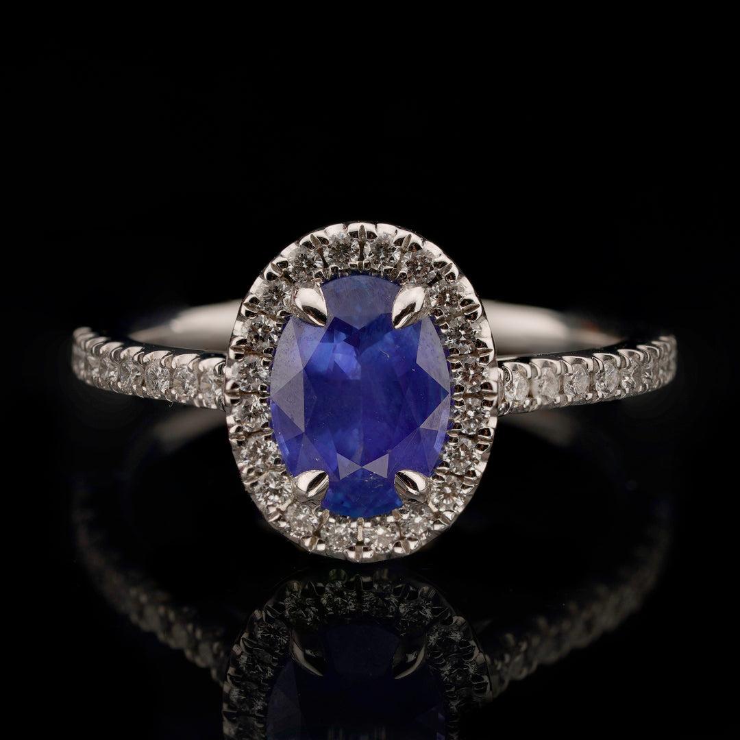 Cette élégante bague de style halo présente 38 diamants blancs ronds éblouissants, flanqués d'un saphir bleu ovale de 1,51 carat, dans un délicat anneau en or blanc 18 carats. Le saphir d'excellente couleur est certifié GIA et 100% non traité.
Nous