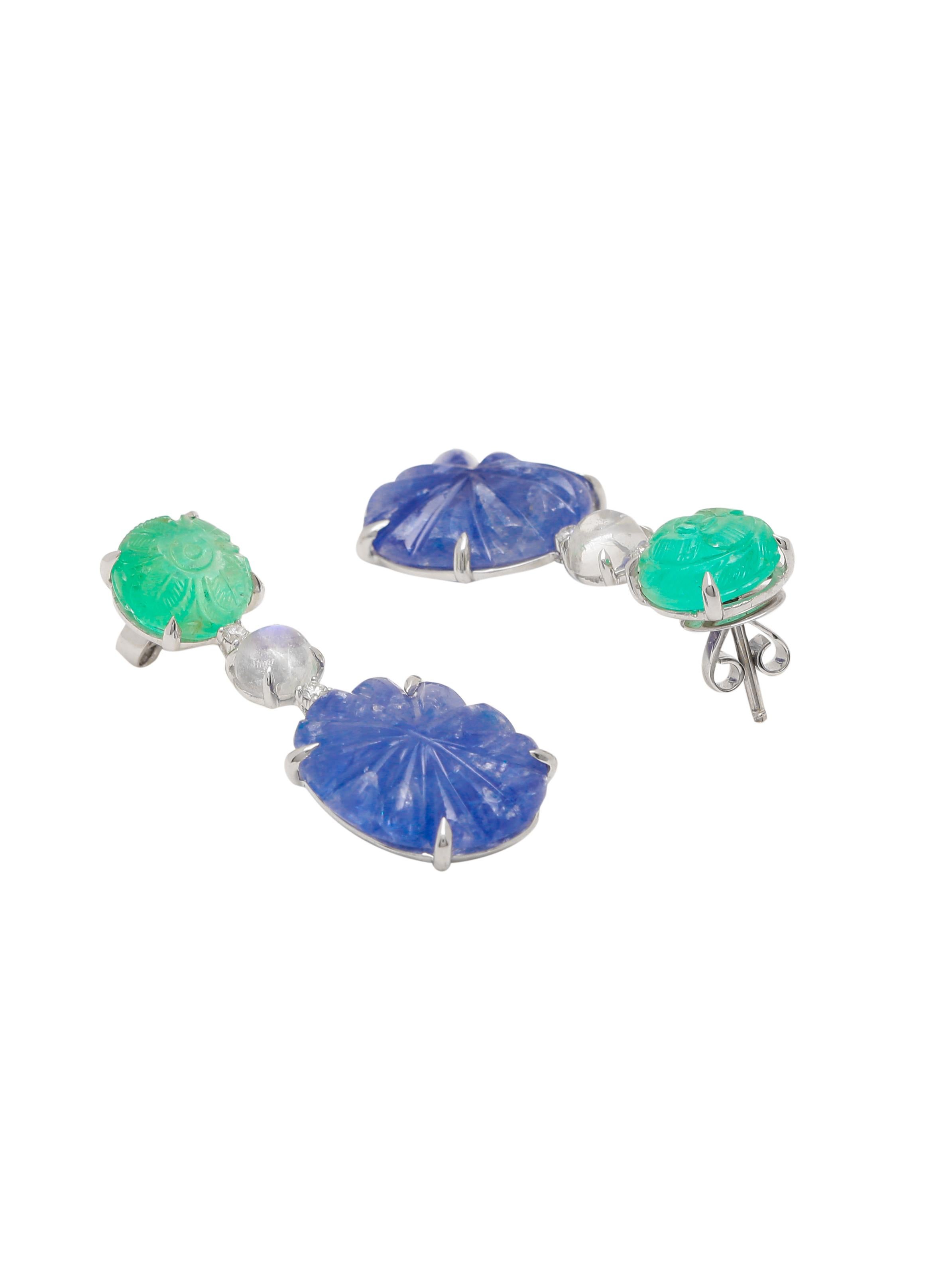 A beautiful necklace and earring set with hand carved natural Sapphire and Emeralds and round rainbow moonstone cabochons and diamonds used as color breakers in the middle. The Natural Emeralds are carved with Floral Motifs. The combination of Blue