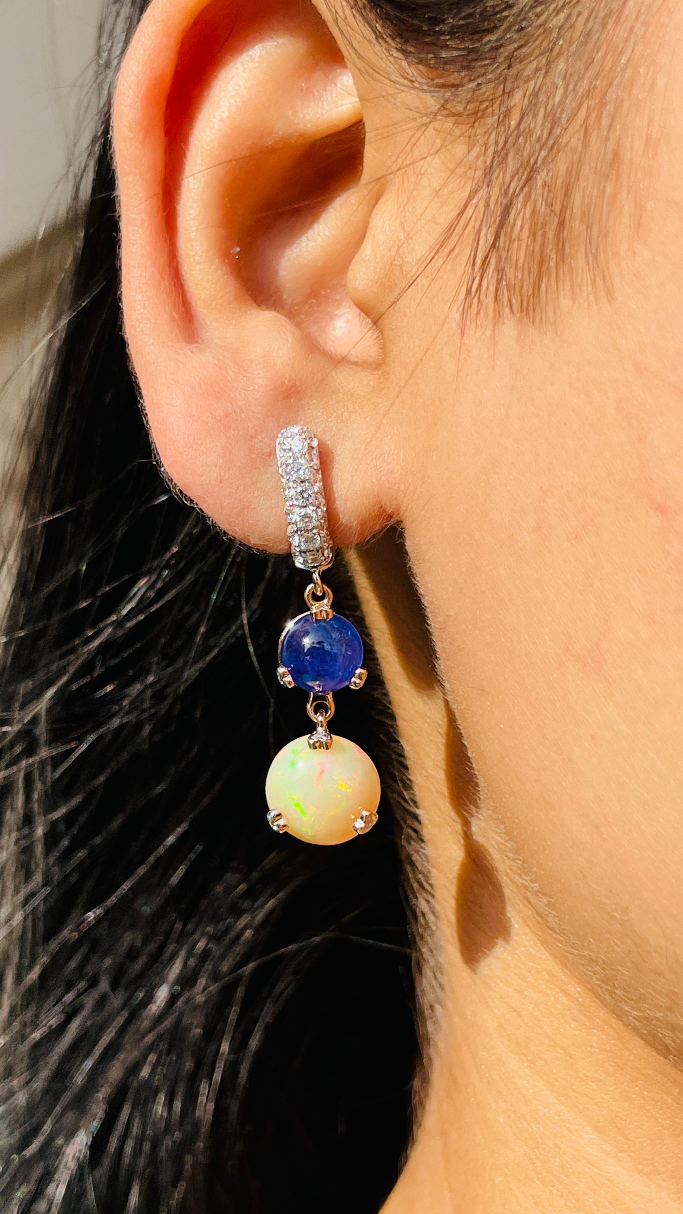Blue Sapphire and Opal Dangle earrings to make a statement with your look. These earrings create a sparkling, luxurious look featuring round cut gemstone.
If you love to gravitate towards unique styles, this piece of jewelry is perfect for