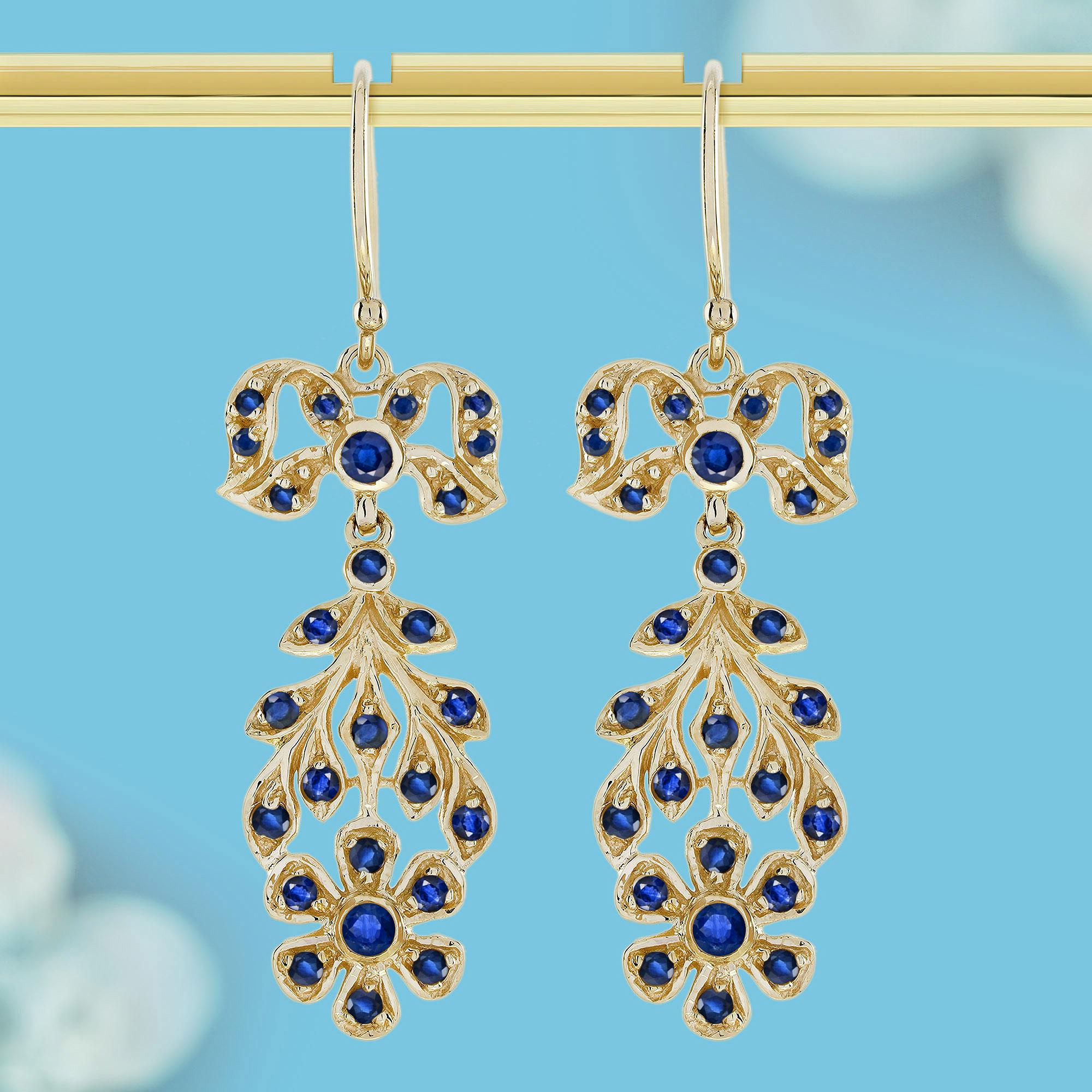 Ein elegantes Hakendesign, das mit den Ohren verbunden wird, gefolgt von einer zarten Schleife, die zu einem schönen blumenförmigen Arrangement führt. Die Blume ist mit leuchtenden Saphiren und schimmernden Perlen verziert, die ihr einen zeitlosen,