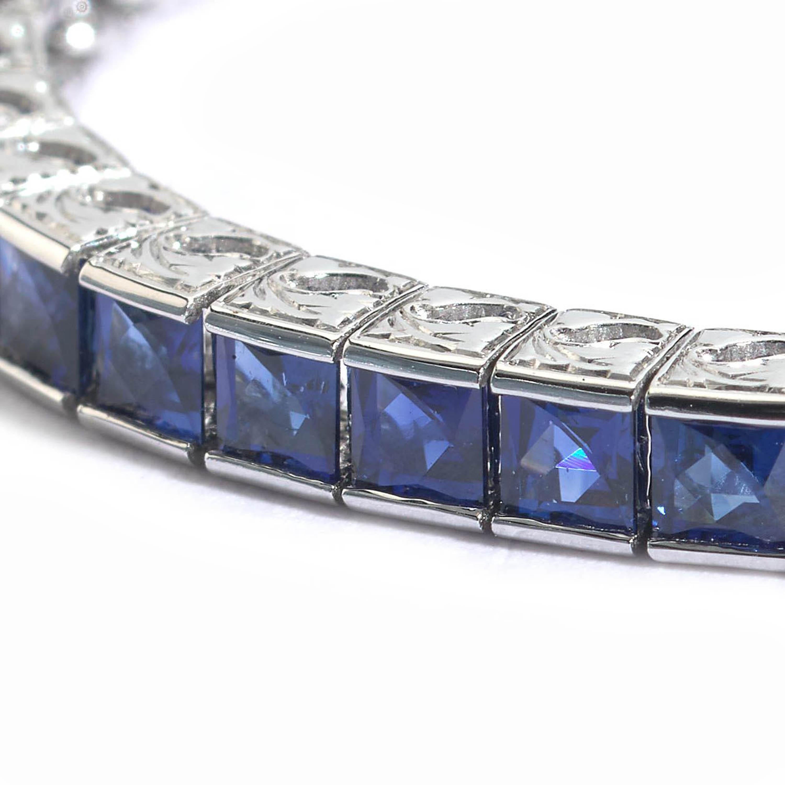 A modern sapphire tennis bracelet, comprised of a single row of French-cut sapphires, with a given total of 9.47 carats, in channel settings, with pierced and engraved sides mounted in 900 platinum.