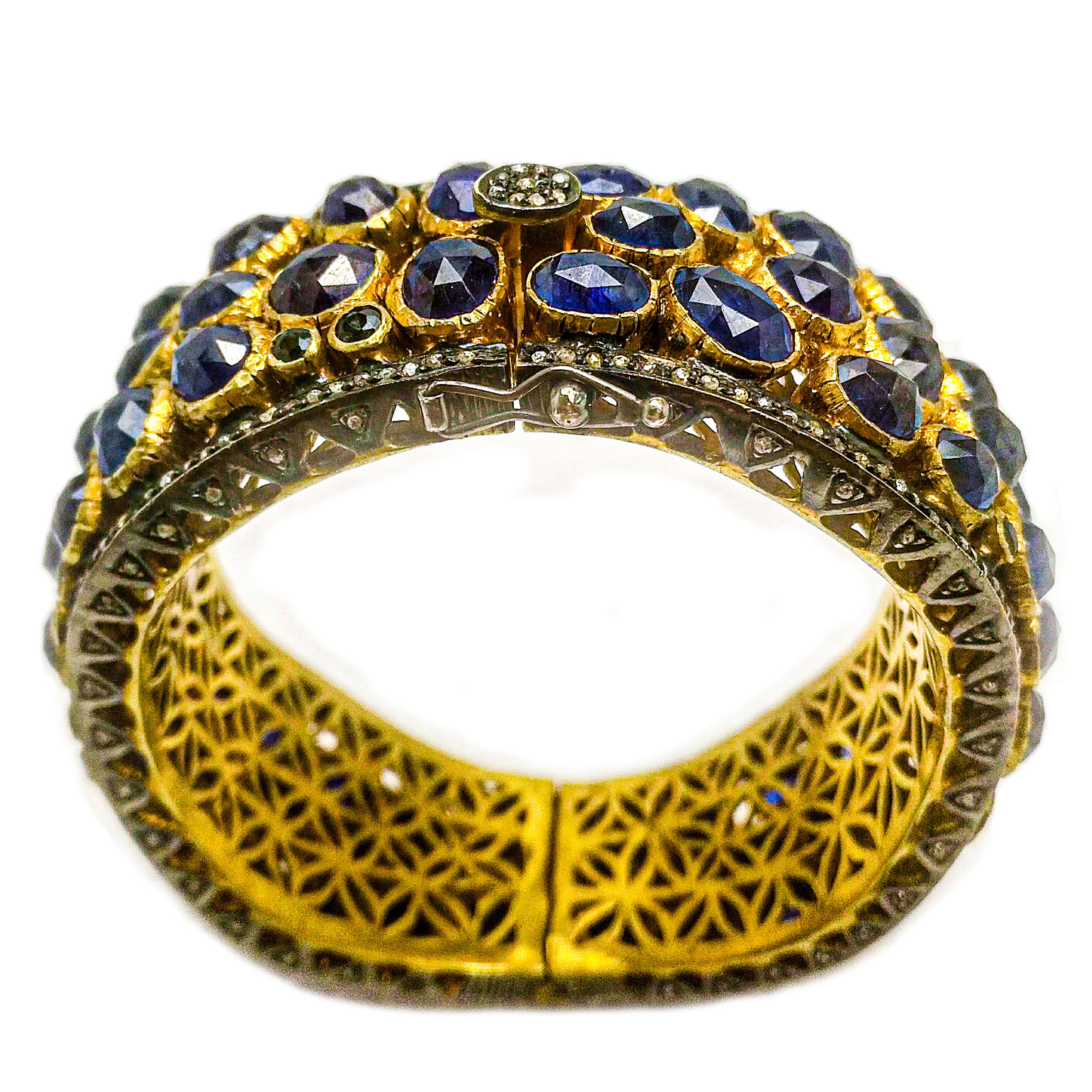Maharaja inspired sapphire diamond bangle. Handcrafted, deep royal blue, 70 carats oval, fancy rose cut, natural sapphires mounted in bezel setting, accented with fancy tabular cut diamonds in micro pave setting with oxidized wavy bangle border.