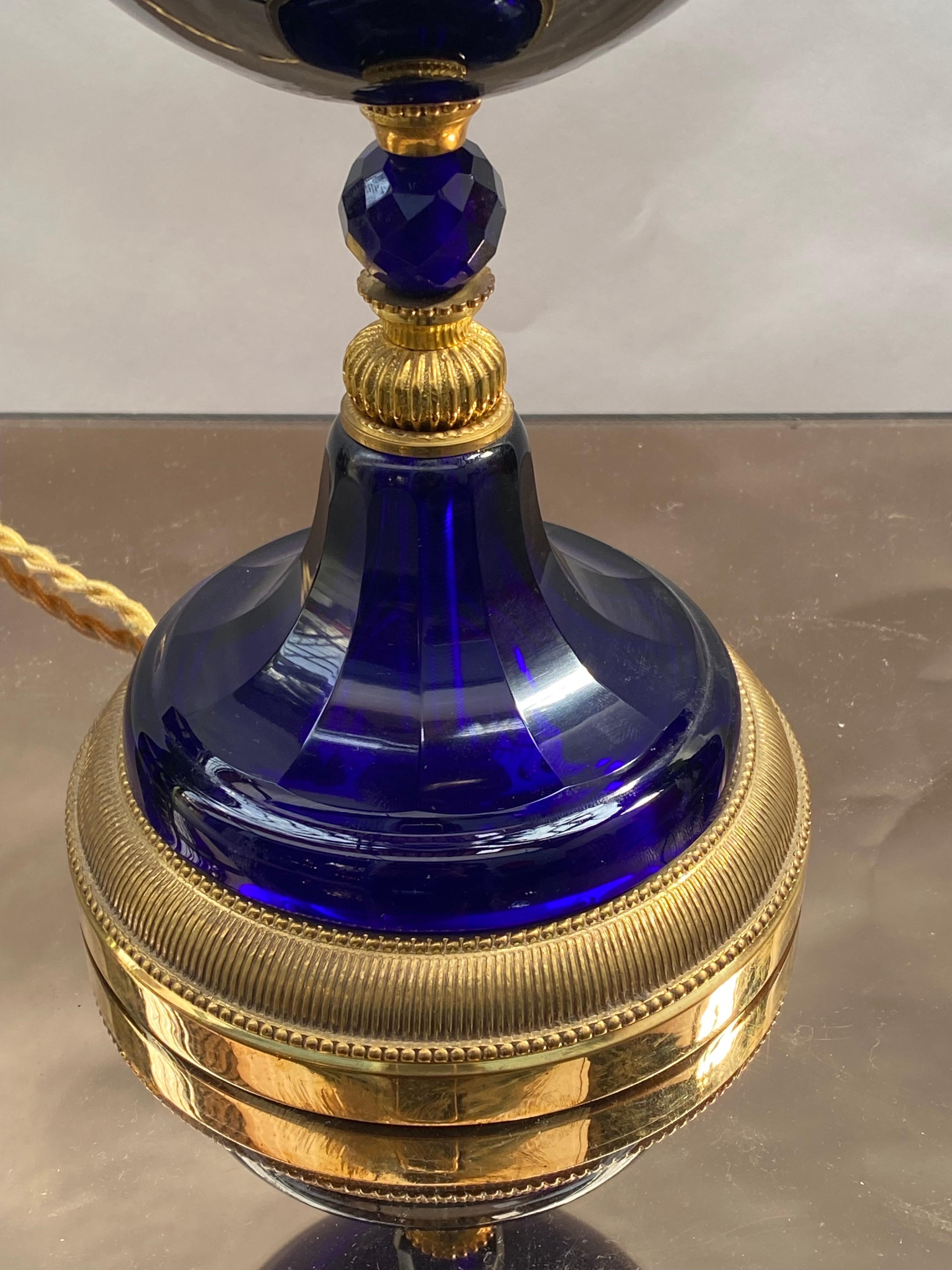 Pied de lampe en cristal bleu saphir, bronze doré. Les pièces en cristal proviennent de l'une des plus anciennes verreries de Paris, la Maison König, rue pastourelle. Malheureusement, cette maison n'existe plus, mais ses cristaux taillés en