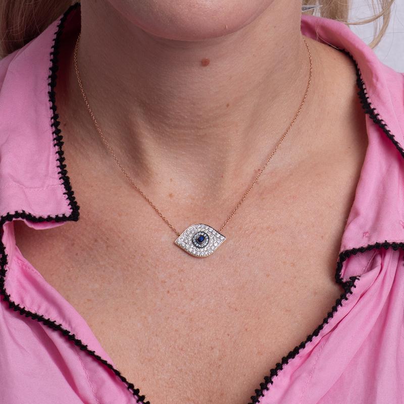 Protect yourself from evil intentions by wearing this evil eye pendant. It features a blue sapphire accented by blue quartz and 0.89 carat total weight in round diamonds set in 14 karat rose gold. It is set on a 16