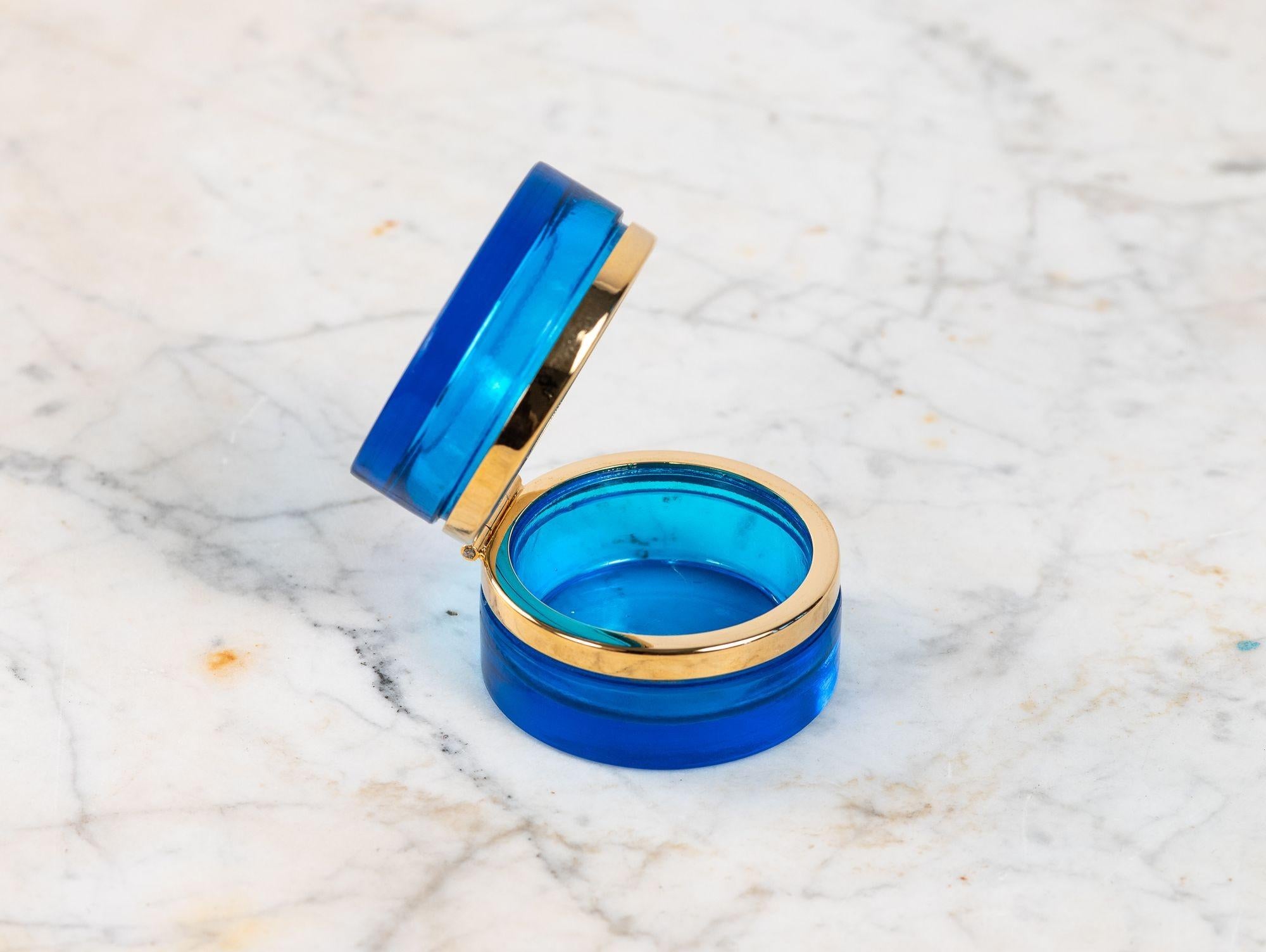 Una rara scatola cilindrica in vetro opalino dalla vibrante tonalità blu zaffiro, risalente agli inizi del XX secolo in Francia. Questo pezzo di grande effetto è caratterizzato da originali montature in bronzo e da un coperchio incernierato, che ne